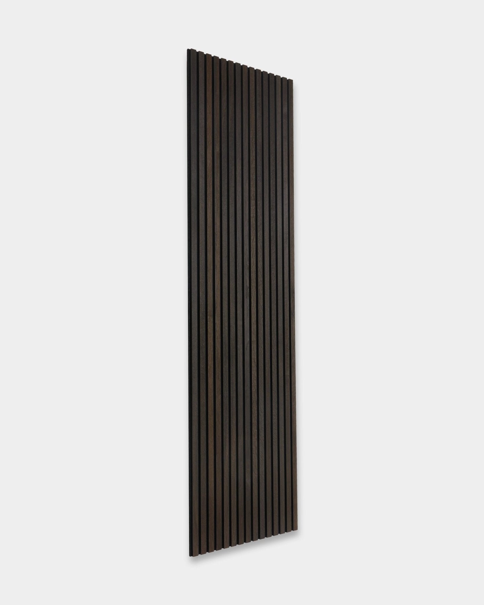 Smoked Oak Akupanel rústico Panel acústico de WoodUpp, con lamas de madera oscura vertical, apoyado contra una pared gris claro.
