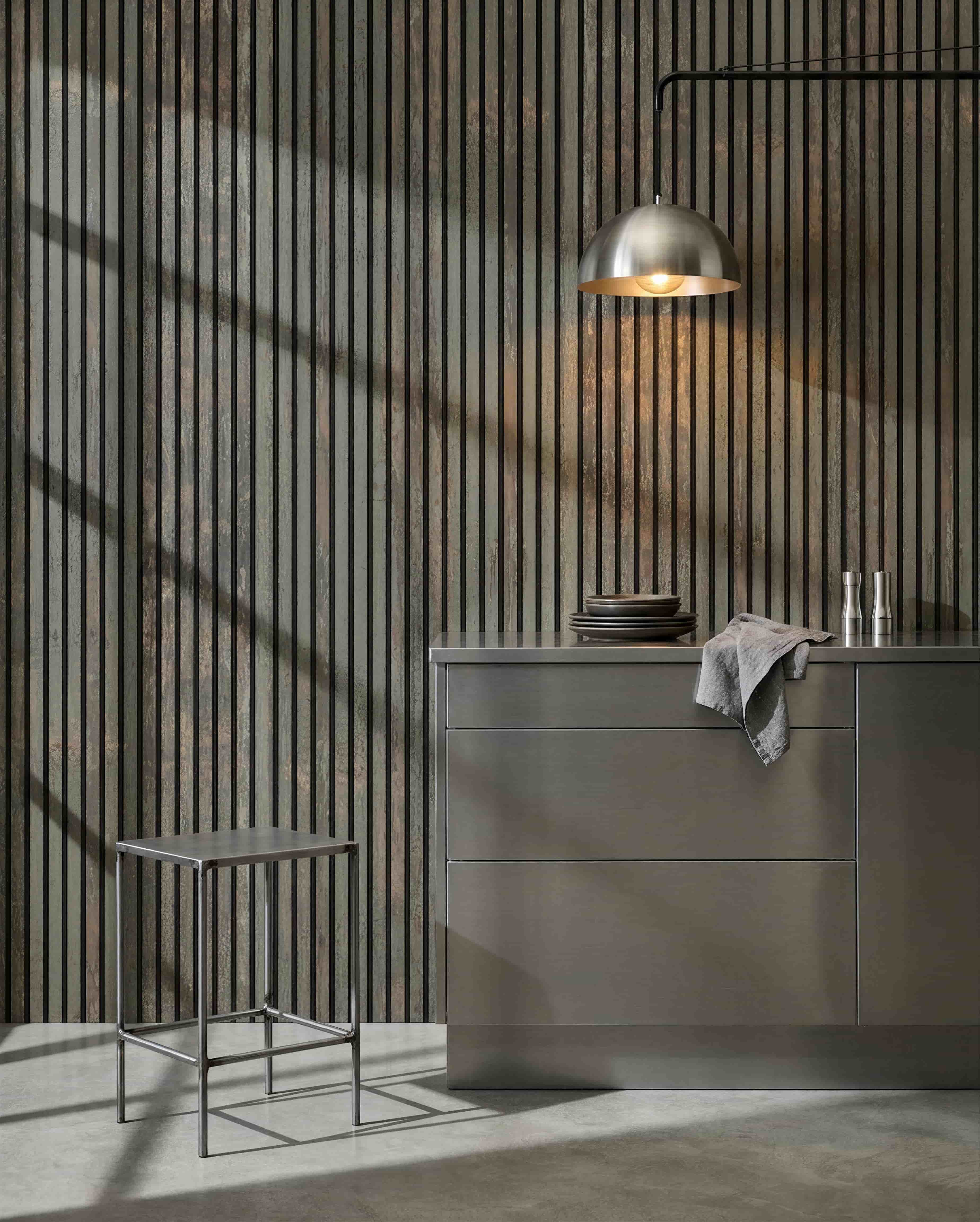 Cocina minimalista con taburete de metal, grey isla y vajilla, con un panel acústico de madera WoodUpp Akupanel en Oxide Grey/Black Felt para el control del sonido.
