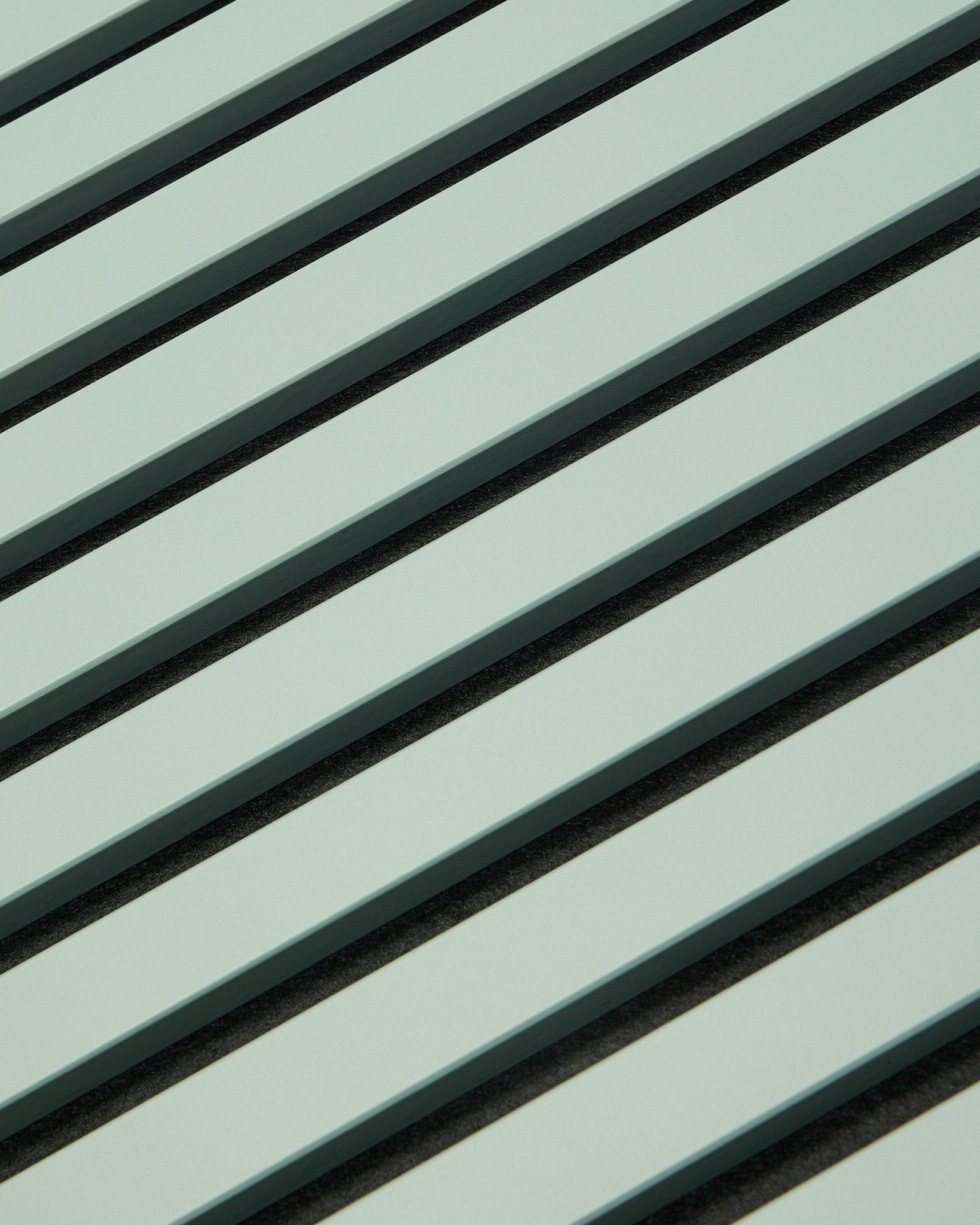 Hue | Akupanel / Cloud de WoodUpp presenta paneles acústicos de madera en verde claro con lamas vertical y separaciones oscuras, creando un patrón geométrico para la absorción acústica.