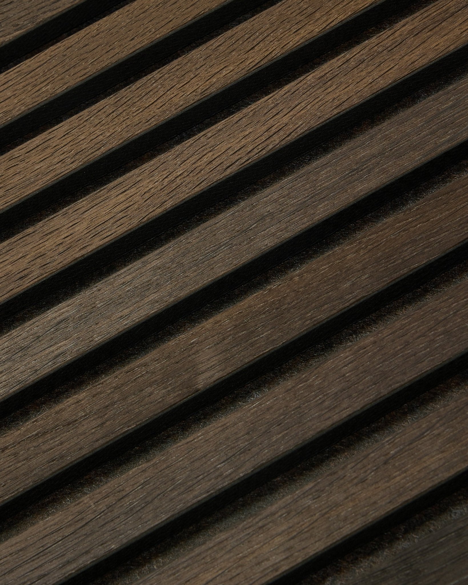 Primer plano de Tonal Akupanel Panel acústico en Smoked Oak (240 x 60 cm) de WoodUpp, con lamas nórdicas diagonales y texturizadas en un diseño escandinavo.