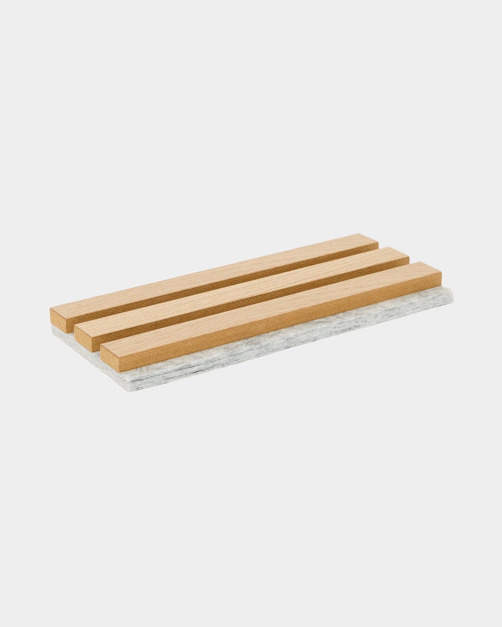 Salvamanteles de muestra de WoodUpp Akupanel con lamas de roble clásico y respaldo de fieltro gris, diseñado para proteger las superficies y mostrar el material acústico nórdico.