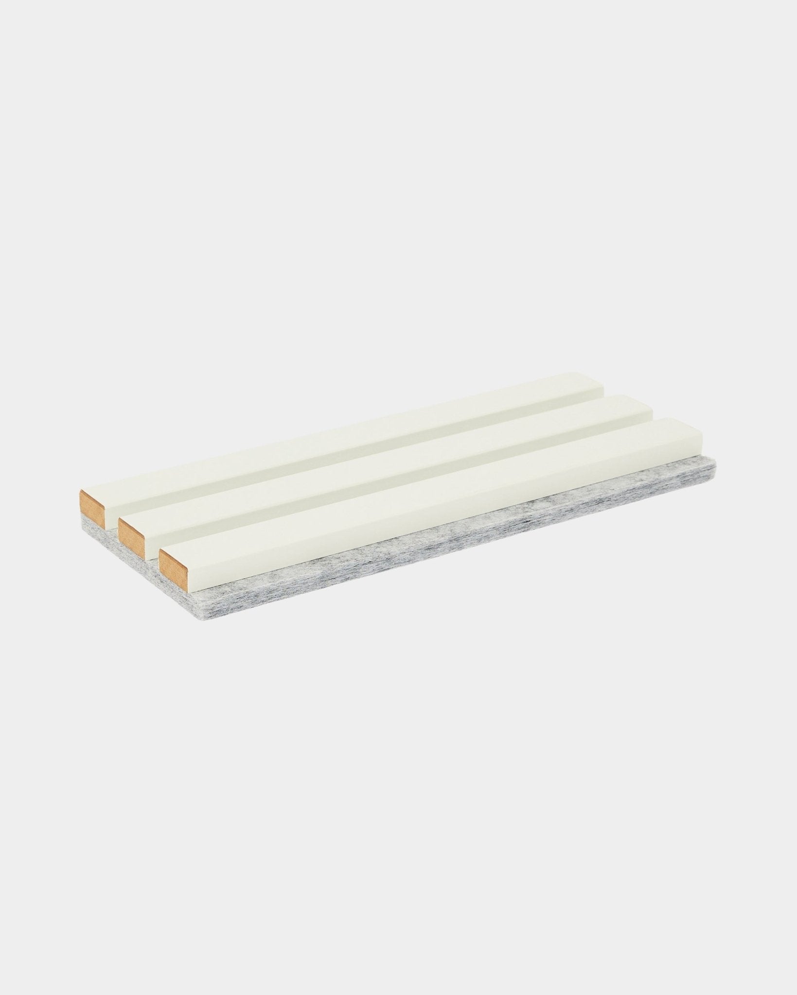 La muestra de tono / Snow de WoodUpp es una esponja de limpieza rectangular con tres franjas blancas y una capa gris resistente para fregar, pensada para el cuidado de Panel acústico.
