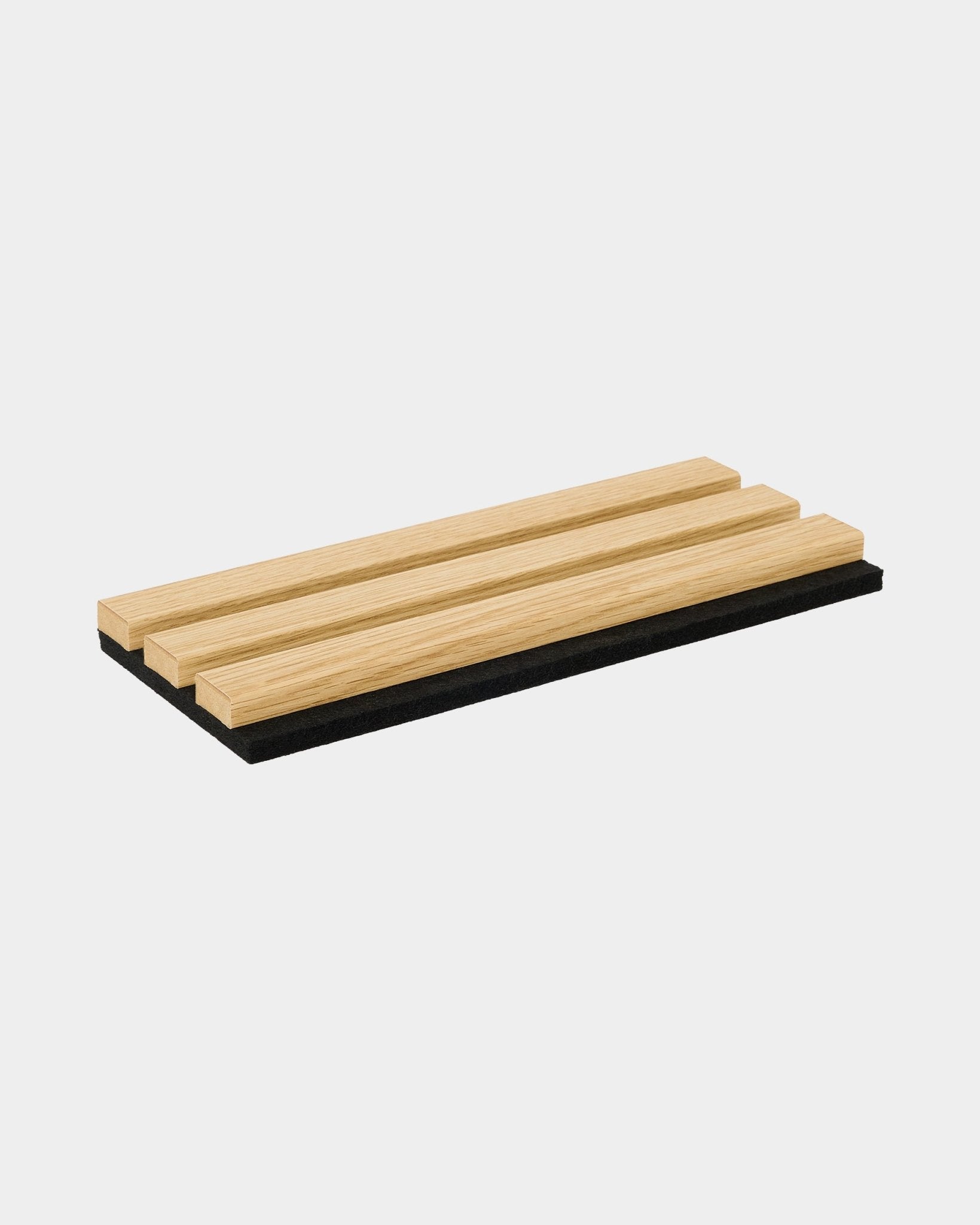 Muestra de WoodUpp Akupanel en Southern Oak, con tres lamas de madera clara sobre una base acústica black y un diseño nórdico minimalista.
