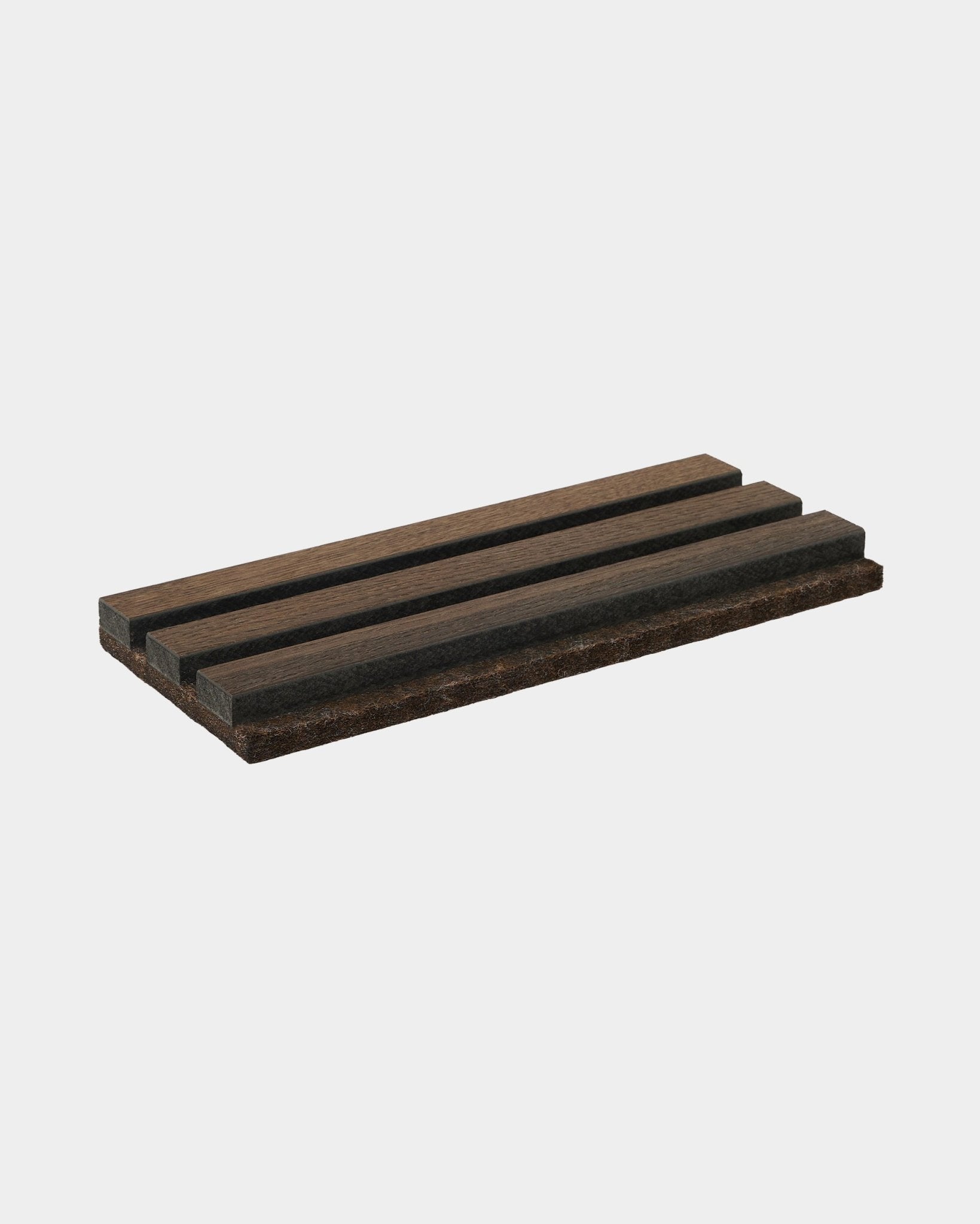 Jabonera Tonal de WoodUpp en smoked oak, fabricada en natural wood, con tres ranuras paralelas; un accesorio diseñado para complementar las colecciones Akupanel.