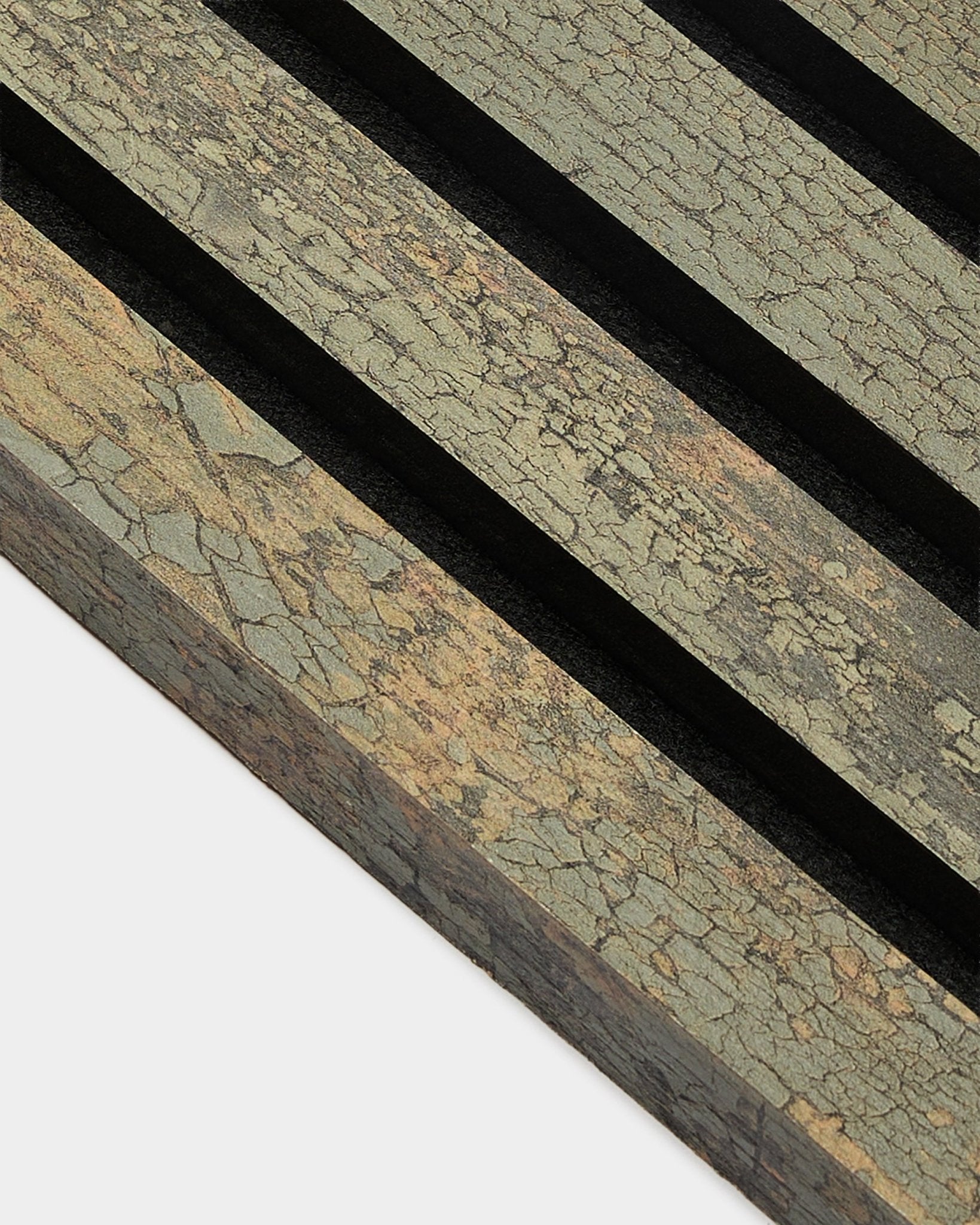 Primer plano de la lámina terminal WoodUpp Akupanel en Oxide Grey, 2,2 cm, que muestra Panel acústico texturizado con ranuras black sobre una superficie en tonos tierra.