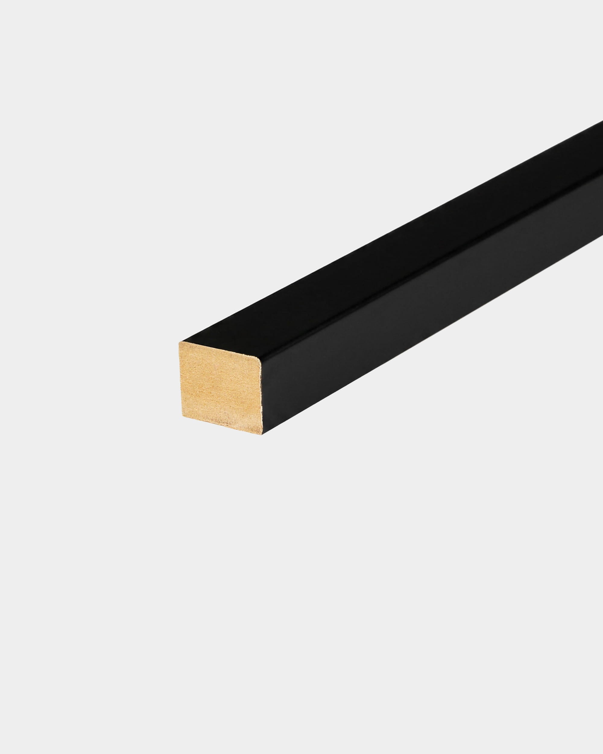 Lámina terminal WoodUpp con revestimiento negro, de 240 x 2,2 cm, con extremo dorado para su instalación en Akupanel, mostrada sobre un fondo blanco.