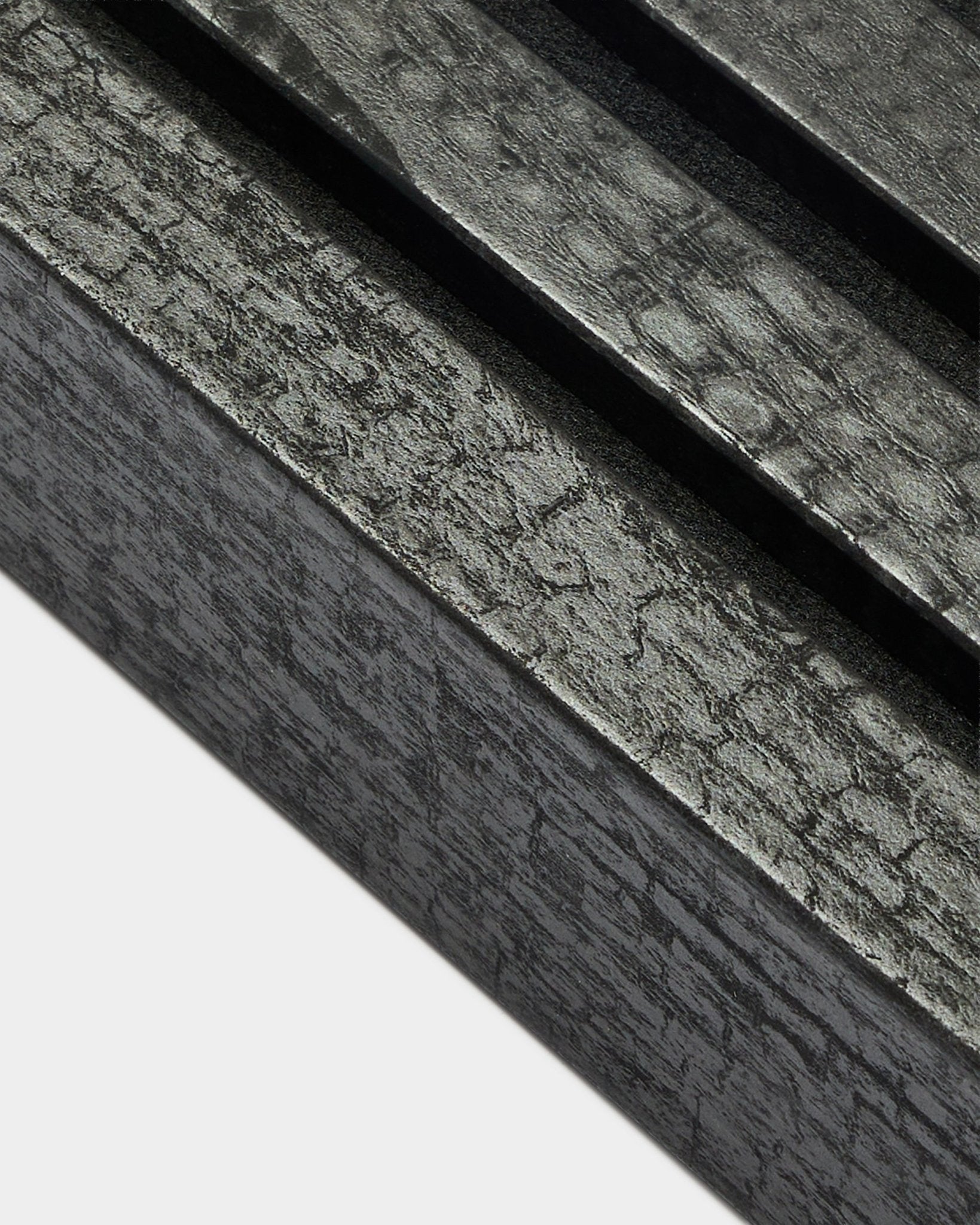 Primer plano de la lama de remate WoodUpp Akupanel en Charcoal, de 6,7 cm de ancho, con lamas acústicas paralelas y una textura de veta de madera distintiva.