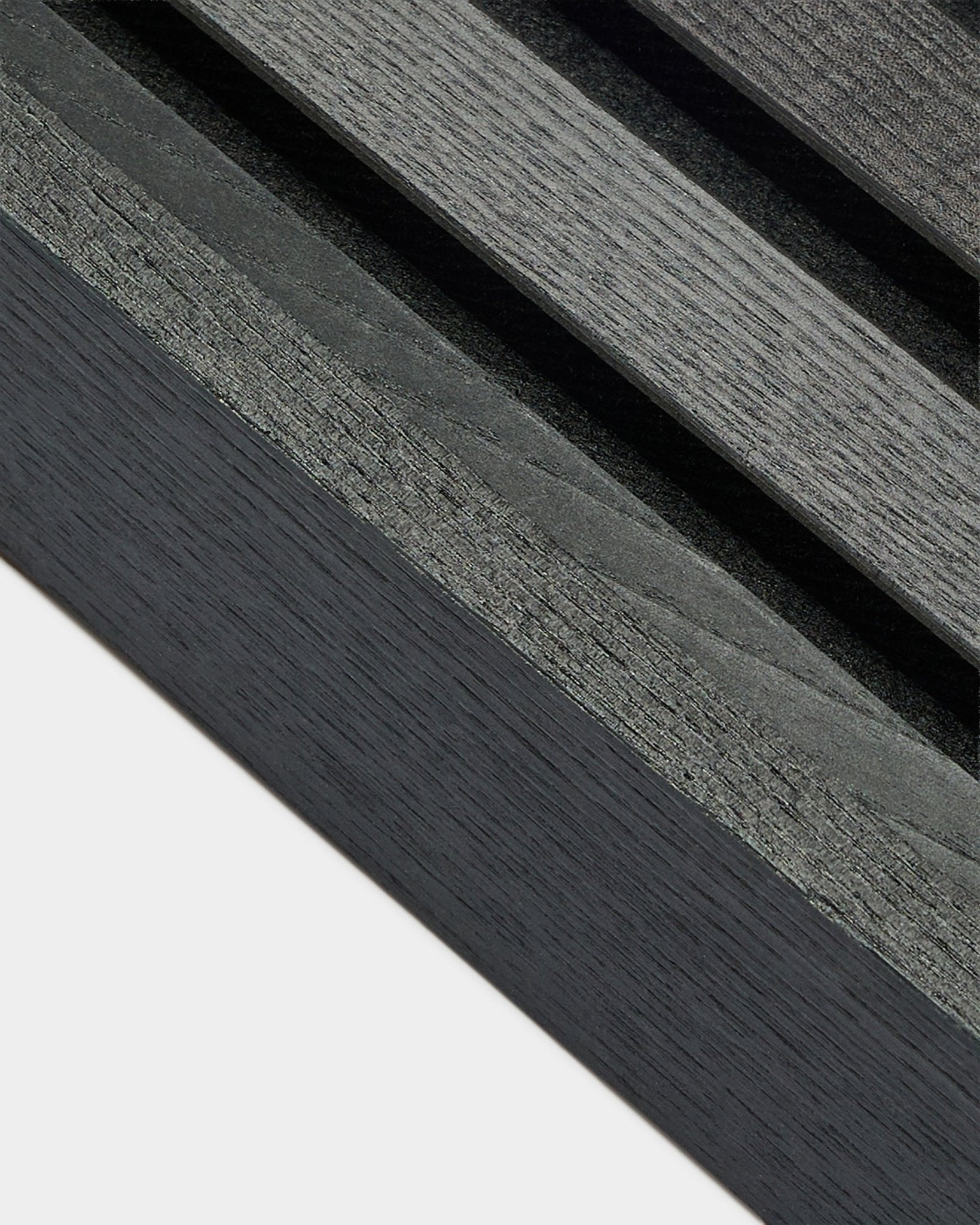 Primer plano de la lámina de extremo WoodUpp Akupanel en Fresno Black (6,7 cm), que muestra una veta de madera gris oscuro sobre una base clara, diseñada para instalaciones nórdicas Panel acústico.