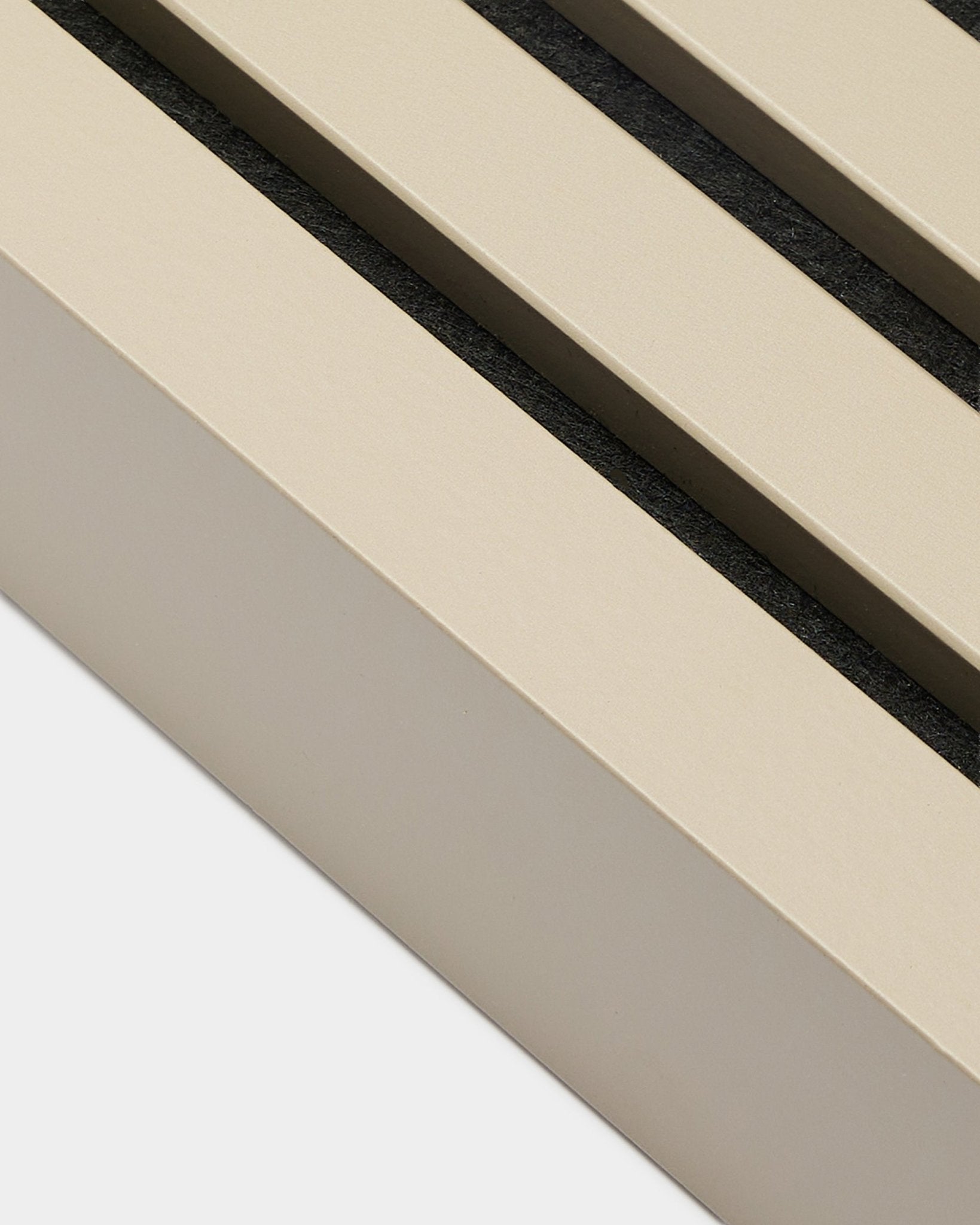 Primer plano de la lámina terminal WoodUpp con acabado Stone, de 6,7 cm de ancho: un accesorio de instalación para marcos de MDF o paneles acústicos Akupanel. Beige lamas del panel con espacios de black.