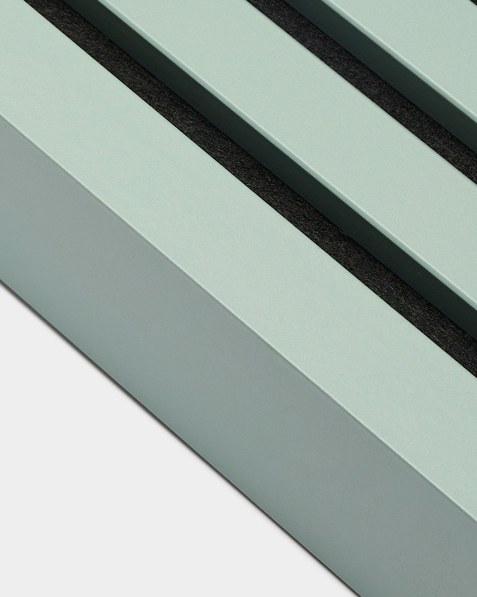 Primer plano del accesorio de instalación WoodUpp Akupanel: End lamella en Cloud, 6.7 cm de ancho, marco de MDF verde menta con dos ranuras black sobre fondo blanco.
