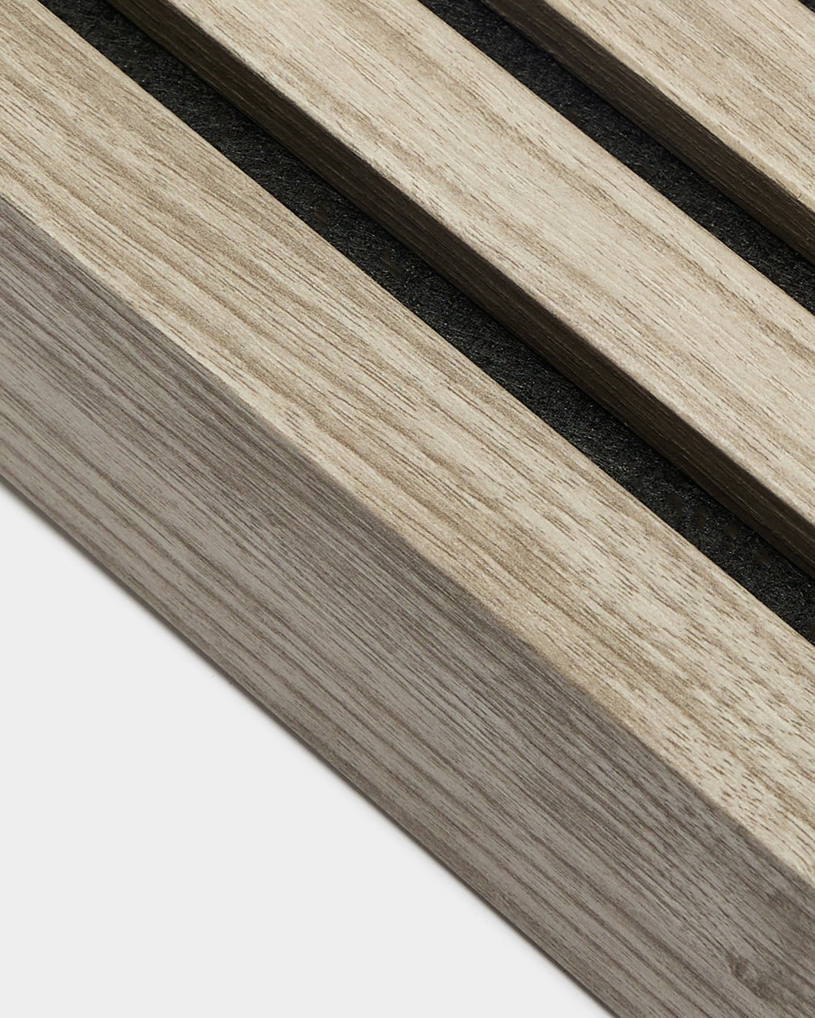 Primer plano de la lámina terminal WoodUpp en Roble Envejecido, de 6,7 cm de ancho, con listones acústicos de madera paralelos con separaciones de black de la gama de productos de instalación.