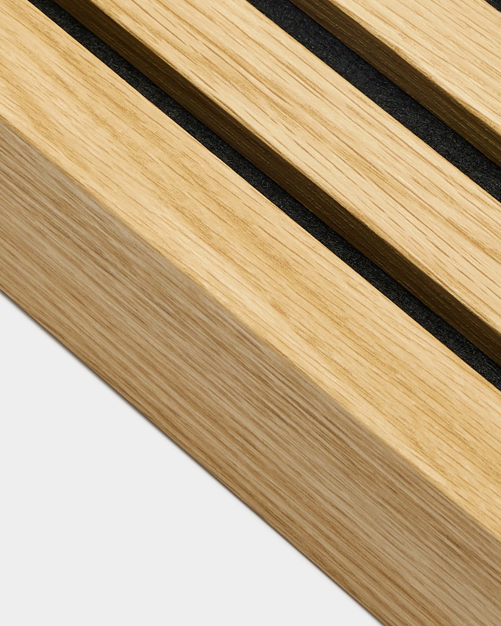 Primer plano del producto de instalación WoodUpp Akupanel, lámina final en Southern Oak, de 6,7 cm de ancho, con ranuras black sobre madera clara para unas líneas de Panel acústico bien definidas.