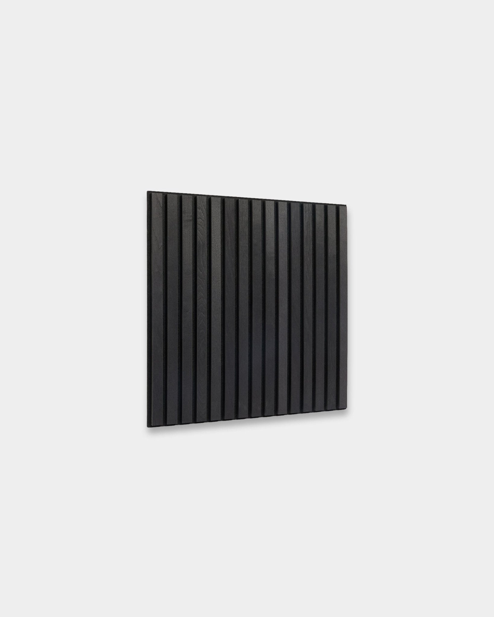 WoodUpp Akupixel Black Ash Panel acústico (60x60 cm) con lamas de madera vertical montadas sobre una pared gris claro, mostrando un diseño escandinavo minimalista.