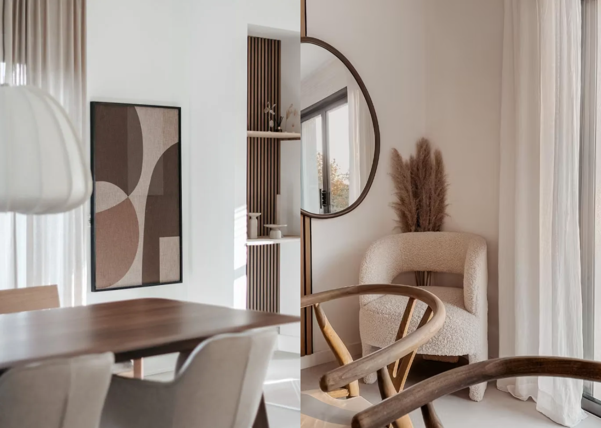 Sala de estar nórdica minimalista con tonos neutros, panel de madera acústica Akupanel como arte de pared, espejo redondo, silla de acento beige, mesa de comedor de madera y centro de mesa de hierba de las pampas.