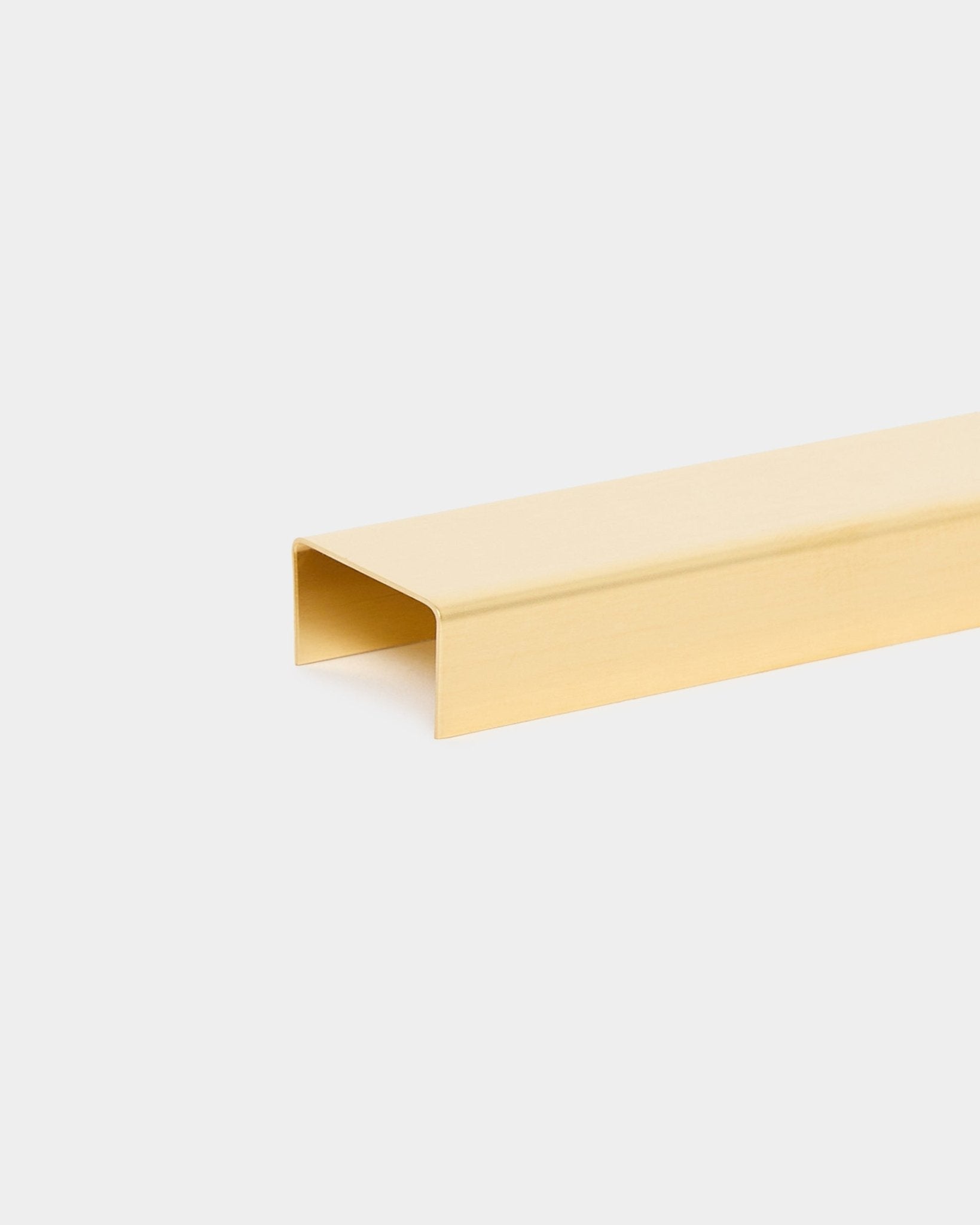 Liva Cover en brass, de 20 cm, de WoodUpp, es un perfil metálico dorado en forma de U diseñado como remate de acabado para los paneles acústicos de madera Akupanel.