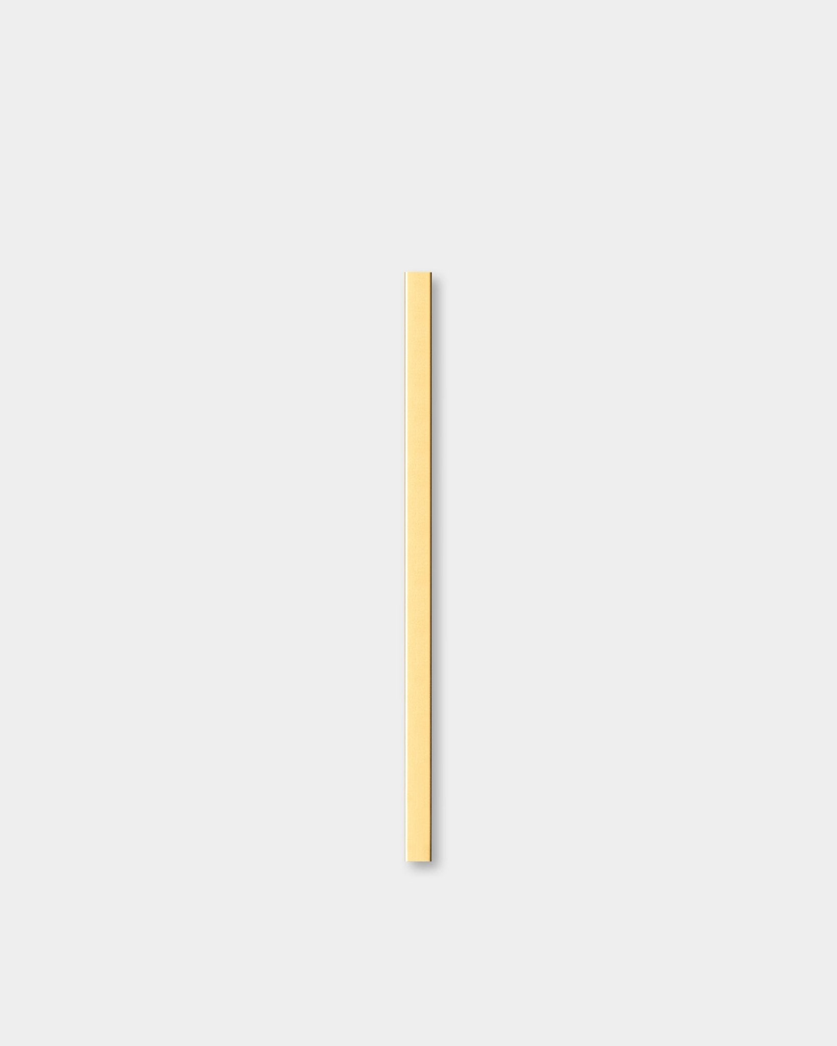 El Liva | Cover en brass, 60 cm de WoodUpp, un Panel acústico, se coloca en vertical sobre un fondo gris claro junto a una moldura decorativa de pared.