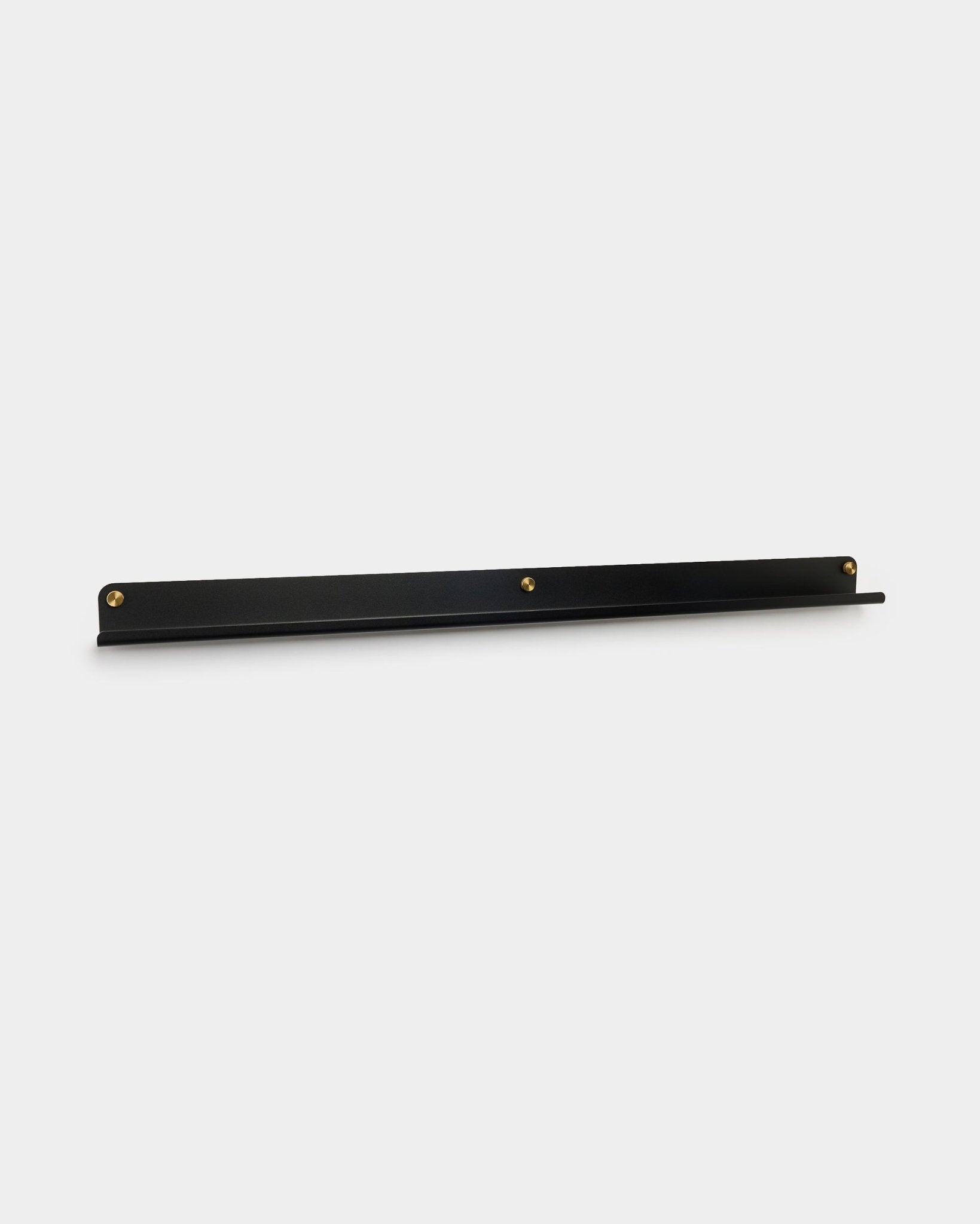 La Narrow Shelf Norr en black de WoodUpp, de 115.9 cm, montada en la pared con tres tornillos de mariposa brass, mostrada sobre un fondo blanco liso.