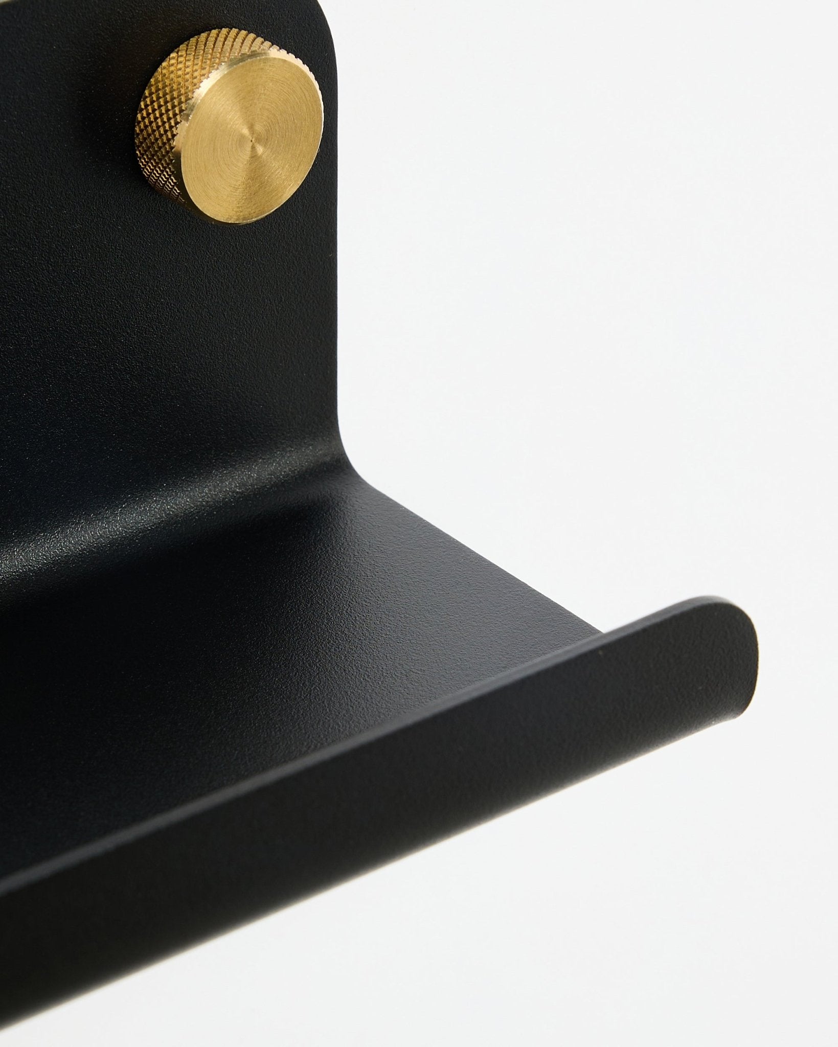 Primer plano del estante estrecho Norr de WoodUpp en black, 75,9 cm, con un pomo dorado texturizado, sobre un fondo blanco.