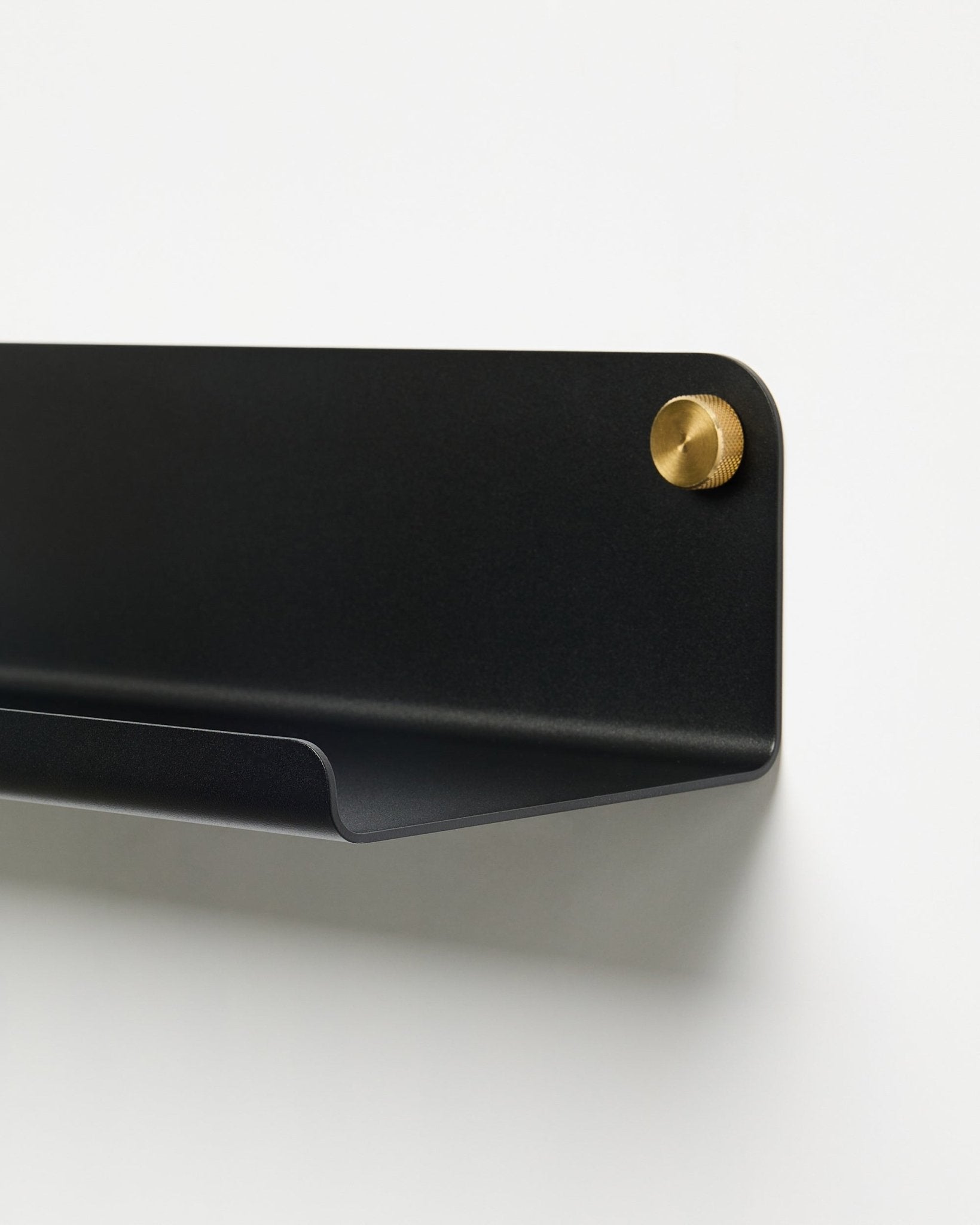 Primer plano del accesorio balda ancha WoodUpp Norr Estantería (51,9 cm) en metal black con recubrimiento en polvo y tornillo dorado, sobre un fondo blanco liso.
