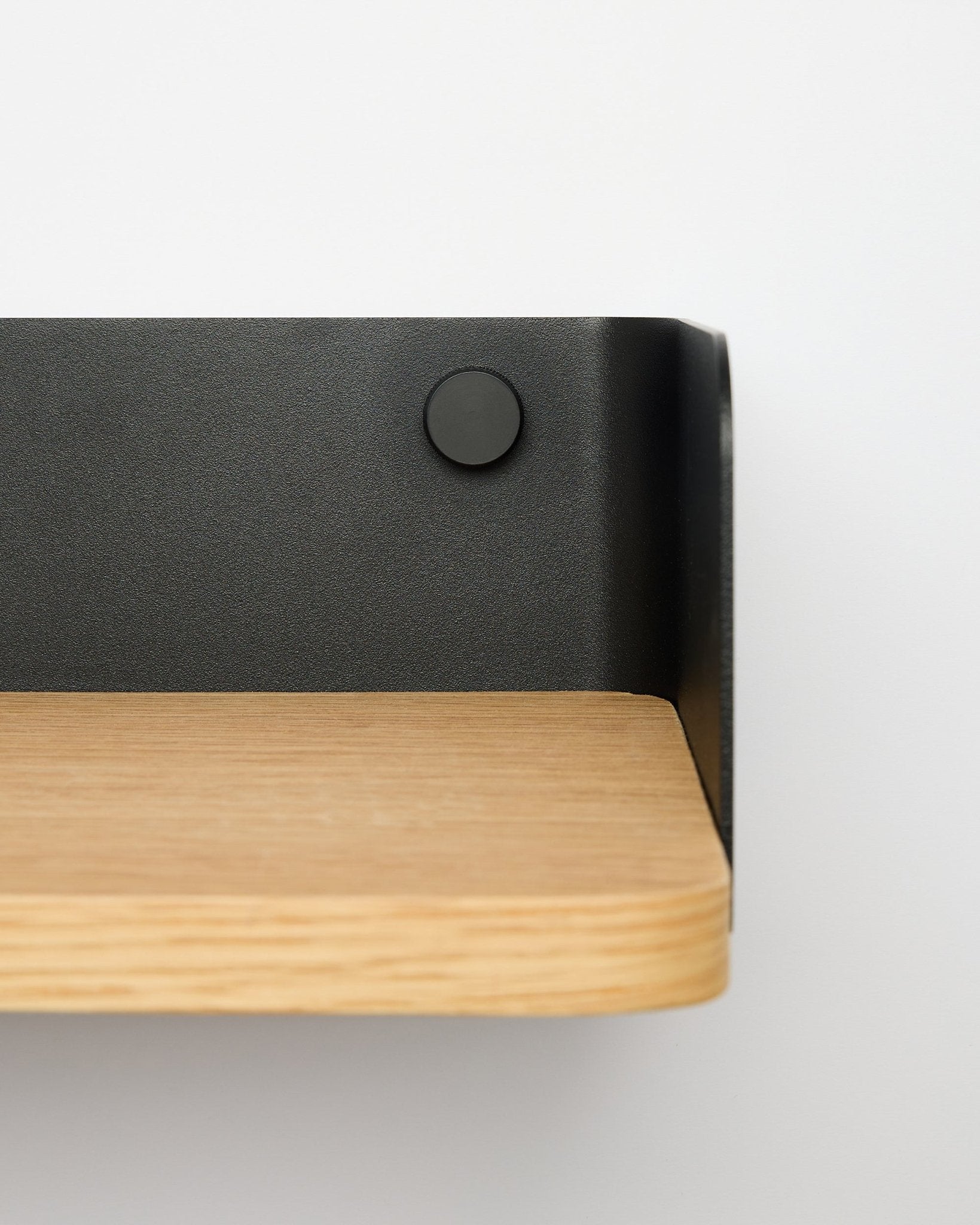 Estantería Linn Bookshelf de WoodUpp en natural oak, de 55,9 cm de ancho, con soporte metálico black, montada en una pared blanca; vista en primer plano desde el lado derecho.