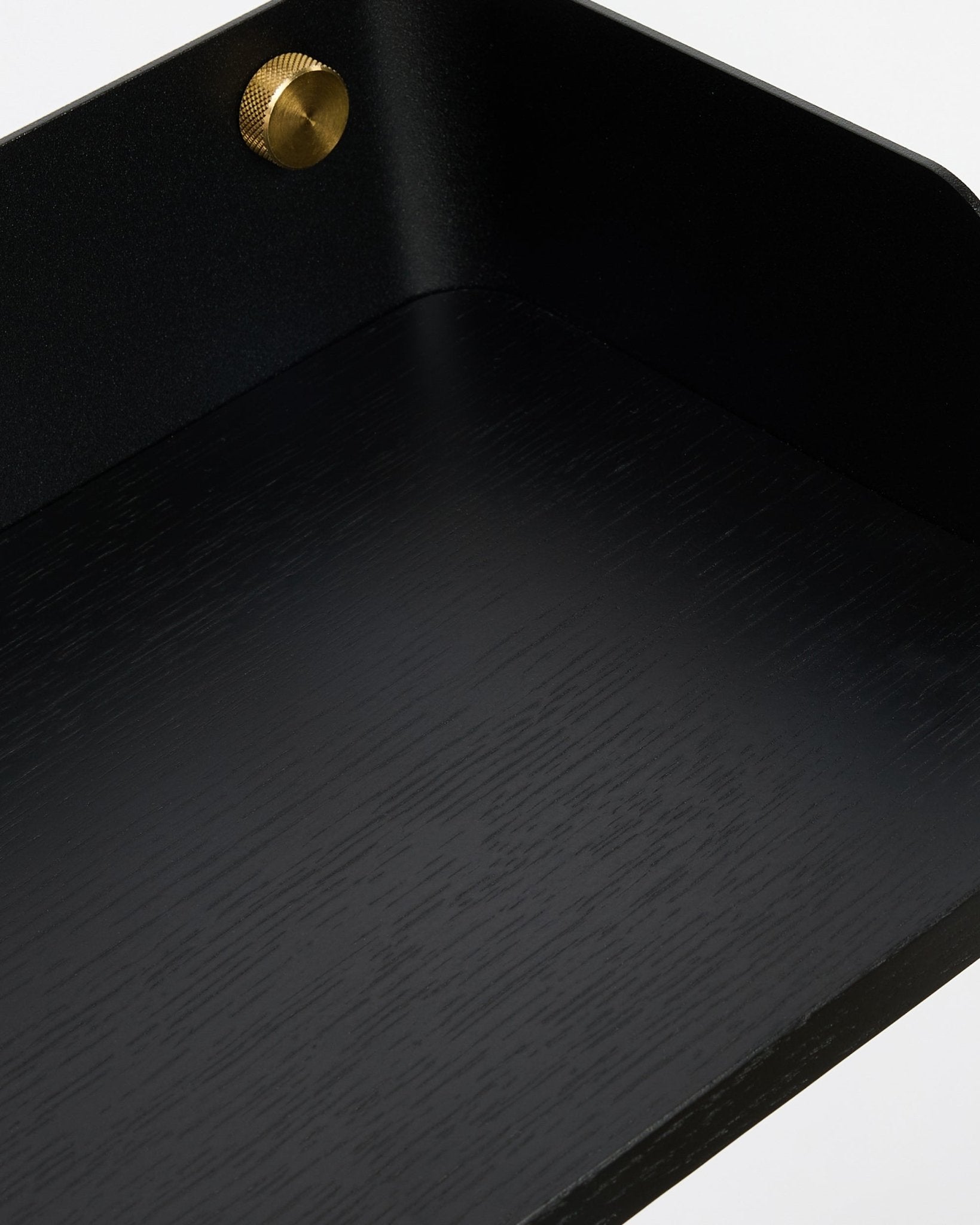 Primer plano de la estantería Bookshelf Linn de WoodUpp en Black Oak (55,9 cm), con la textura de la veta de madera nórdica y el detalle de los tornillos dorados, diseñada para combinar con la colección Akupanel.