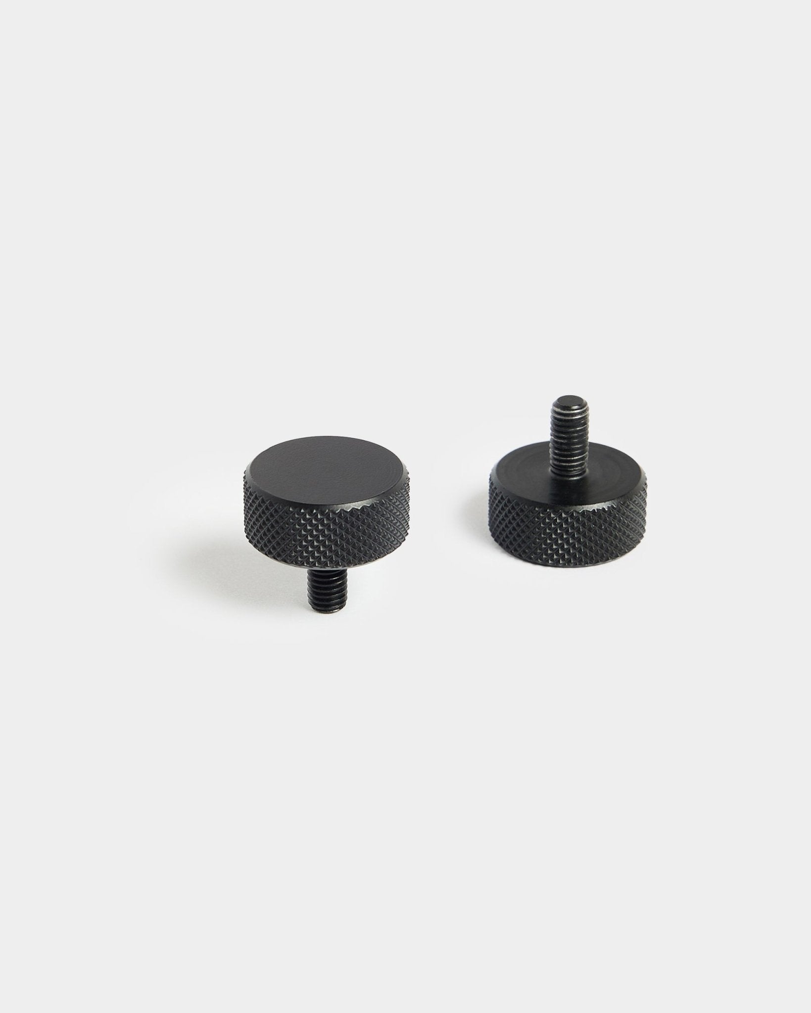 Par de tornillos Finger de WoodUpp black (M5x10 mm, 20x8.8) con bordes moleteados, diseñados para usarse con accesorios Panel acústico, sobre un fondo blanco liso.