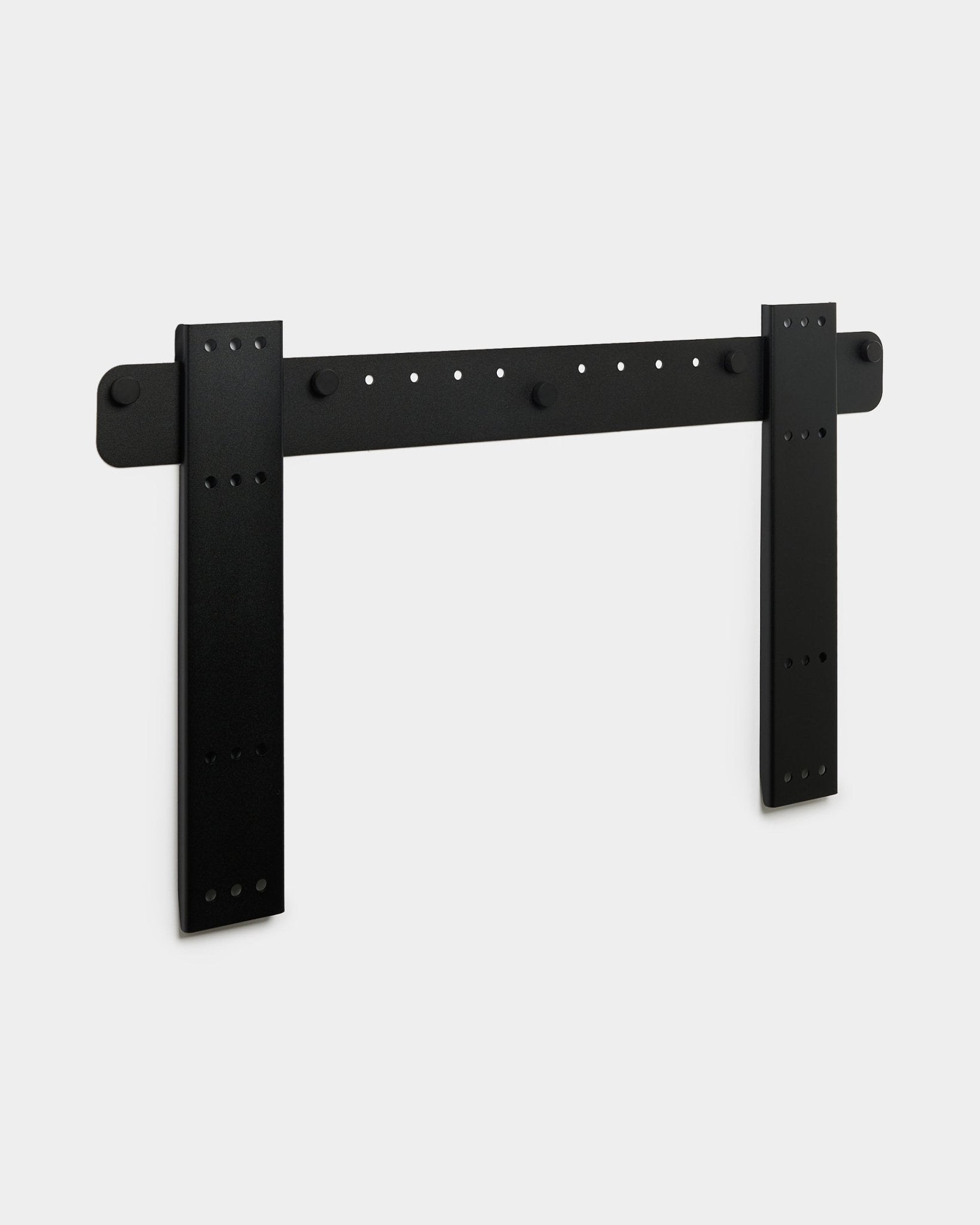 Soporte de TV WoodUpp Fjell Large con doble soporte vertical, compatible con VESA 600x400, acabado en metal black sobre un fondo gris claro.