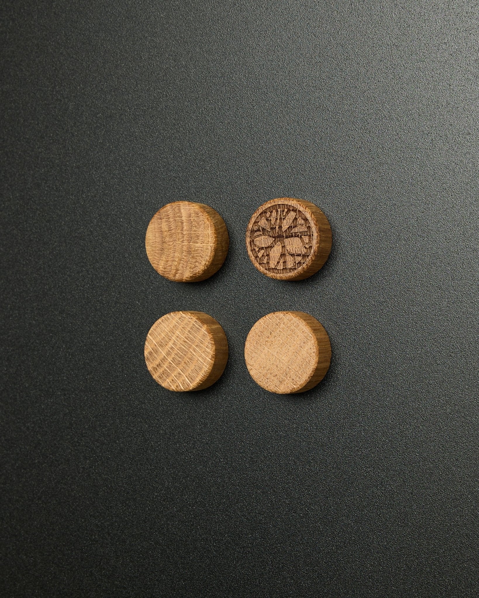 Set de cuatro imanes macizos de natural oak de WoodUpp, uno de ellos con un diseño tallado de rodaja de cítrico, pensados para usar con el Norr Magnetic Board Panel acústico.