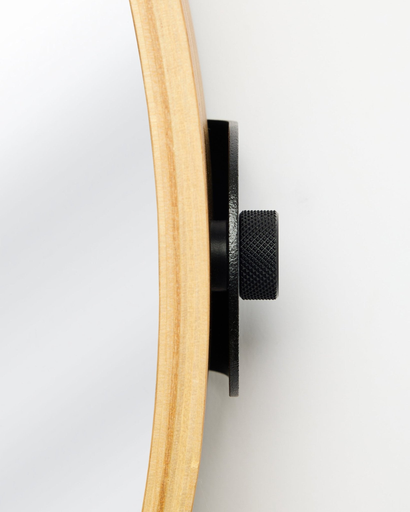 Vista lateral en primer plano del Linn | Mirror de WoodUpp en Natural Oak, con un marco redondo de roble y un pomo metálico black, accesorio para paneles acústicos de madera.