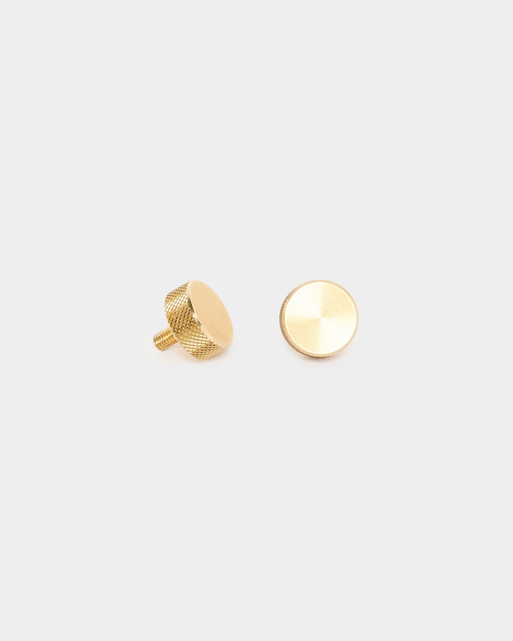 Par de tornillos moleteados WoodUpp brass (M5x10 mm, 20x8.8), con laterales texturizados y postes roscados, diseñados como accesorios para montar paneles acústicos o separadores de ambientes.
