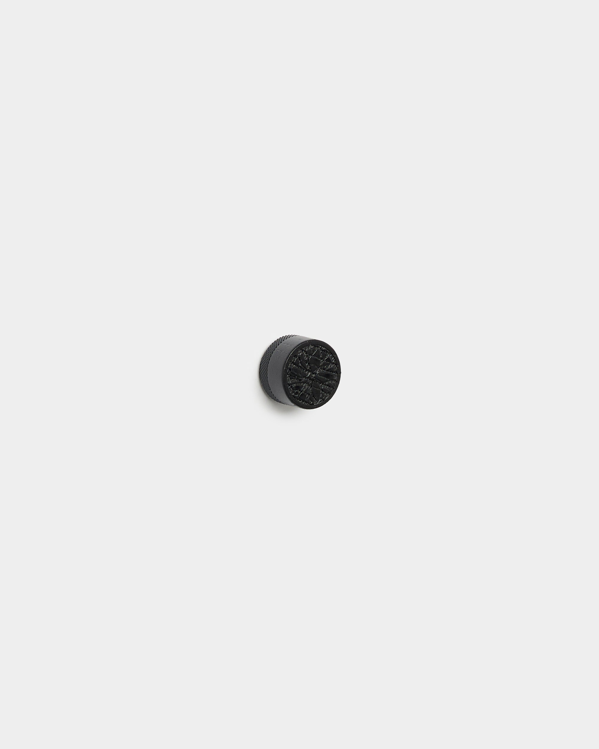 Juego de imanes para póster de WoodUpp con pomos redondos small black oak para fijar fotos sobre un fondo de panel acústico de madera Akupanel gris claro.