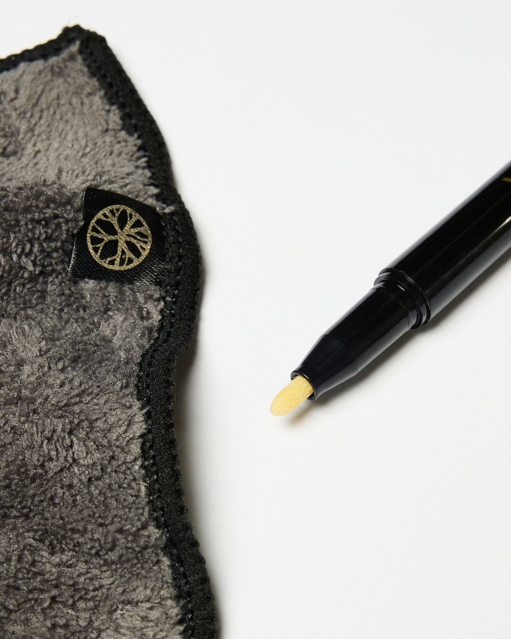 El set Blackboard Norr de WoodUpp incluye un rotulador de tinta de tiza black con punta amarilla y un paño de microfibra gris con etiqueta dorada, presentado sobre una superficie blanca.