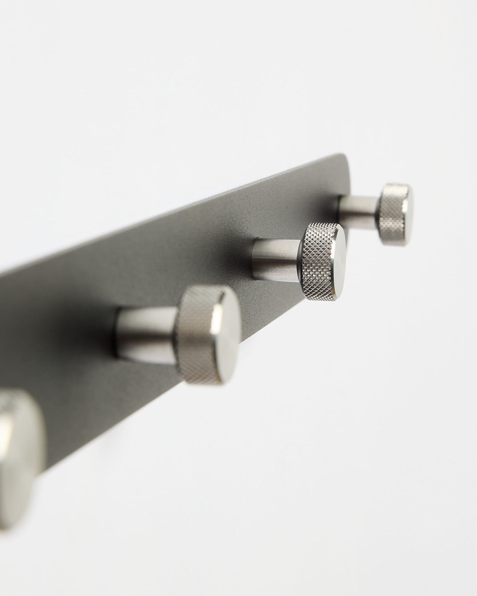 Perchero con ganchos WoodUpp Norr Coat Hook Rack X7 en negro y acero inoxidable con siete ganchos, mostrado sobre un fondo blanco liso; forma parte de la colección de accesorios CREATE.