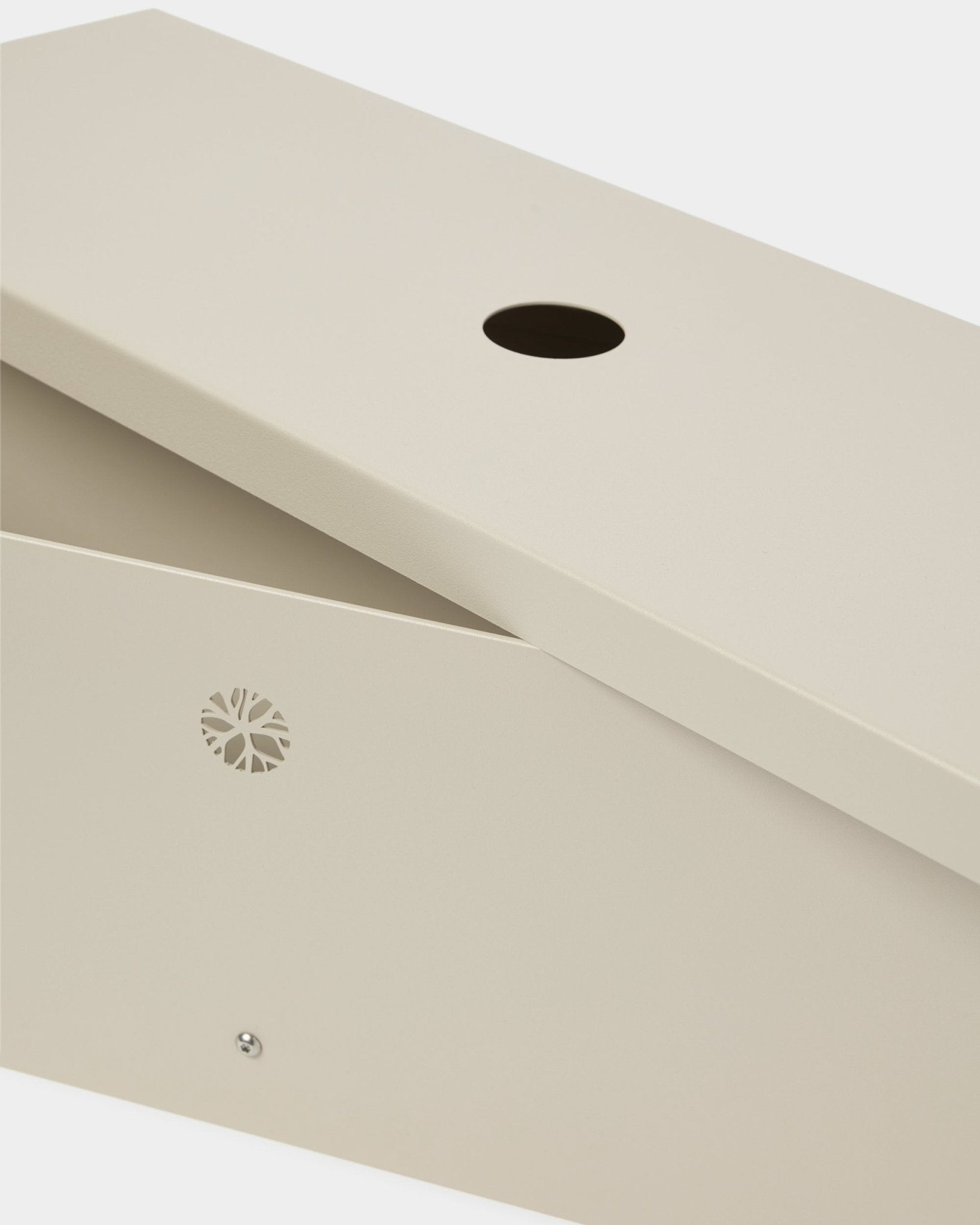 El Nell | Metal Box / BM2, Beige de WoodUpp, fabricado en steel con recubrimiento en polvo, con tapa inclinada, abertura circular y un discreto emblema lateral.