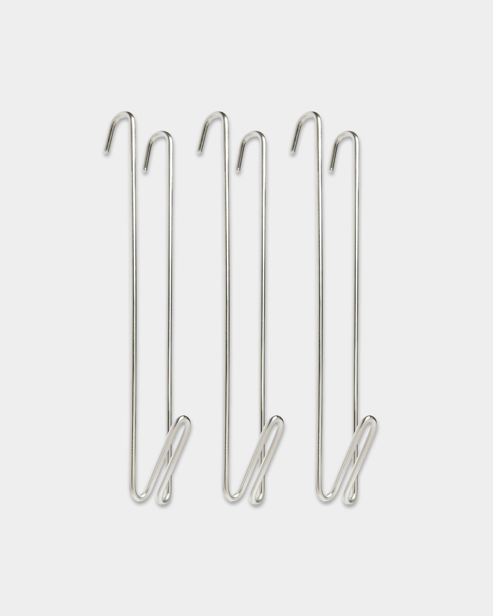 Tres extensores para barra de armario Alva de WoodUpp, de acero inoxidable con steel y BM1, diseñados para añadir más espacio de colgado junto a paneles acústicos de madera.
