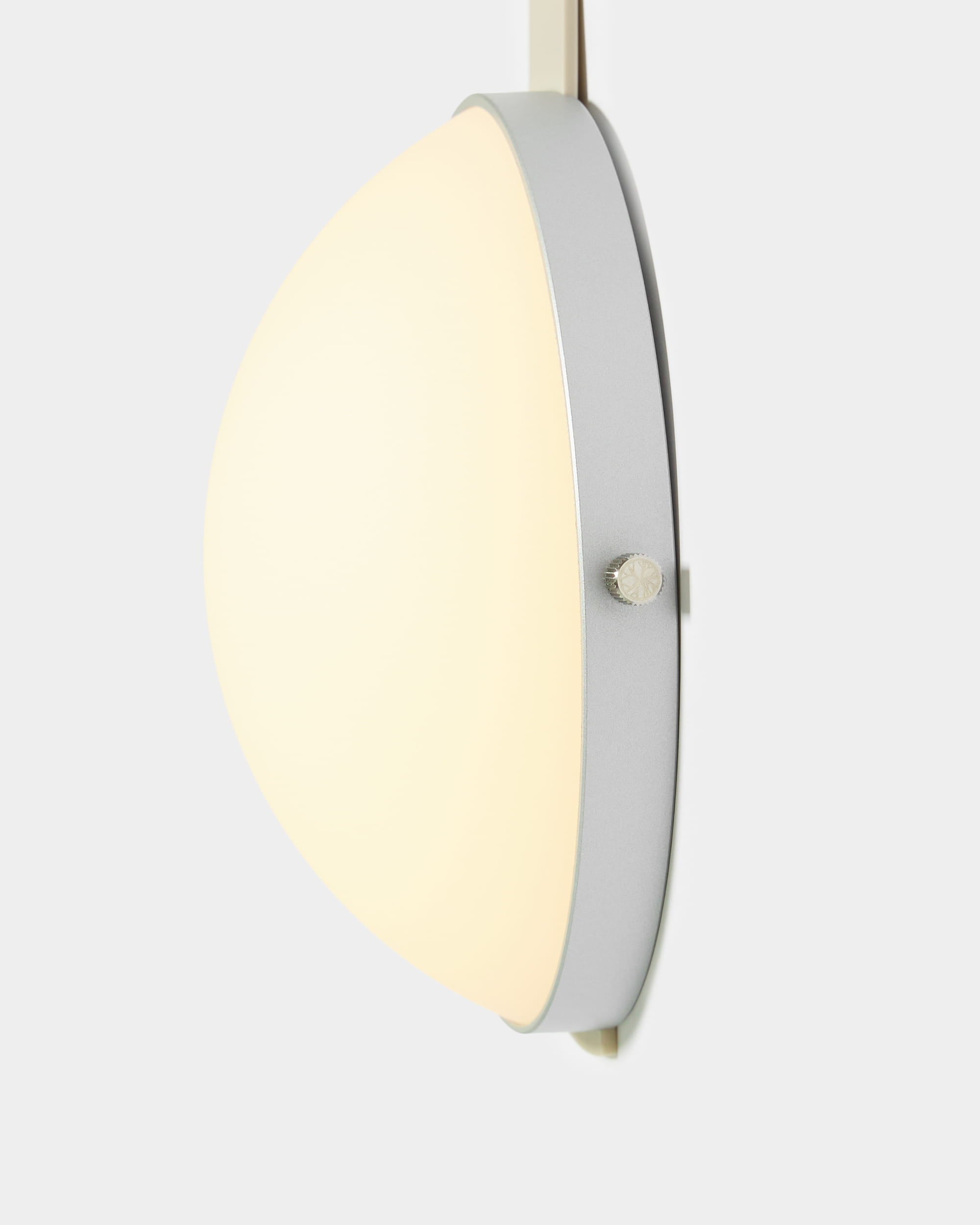 Lámpara LED portátil «Vala» de WoodUpp, con pantalla de cristal esmerilado en forma de semiesfera y estructura plateada, expuesta sobre un fondo gris claro.