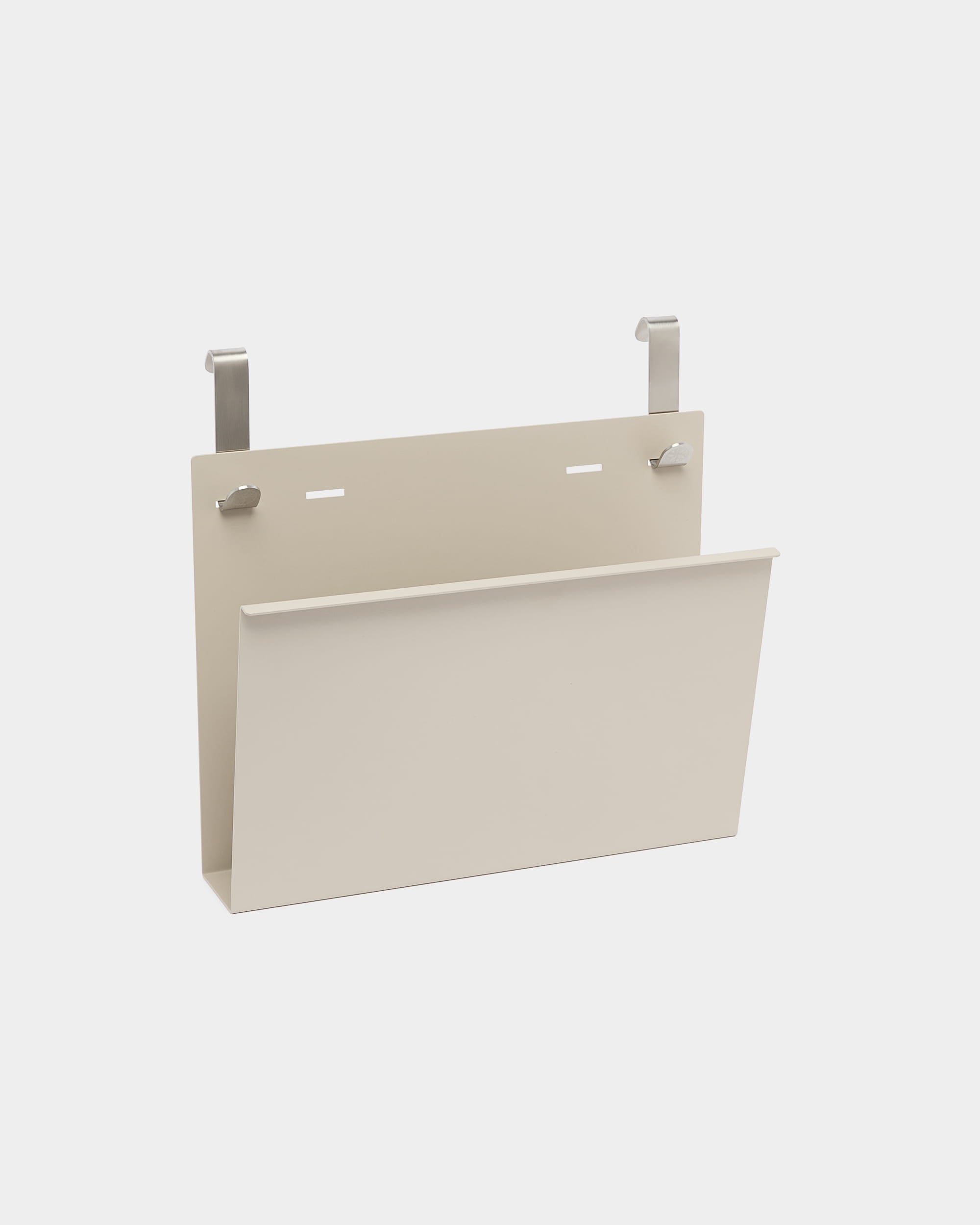 El revistero Nell de WoodUpp es un soporte de beige con recubrimiento en polvo de steel, con dos ganchos plateados para colgarlo en separadores o particiones acústicas Nordic.