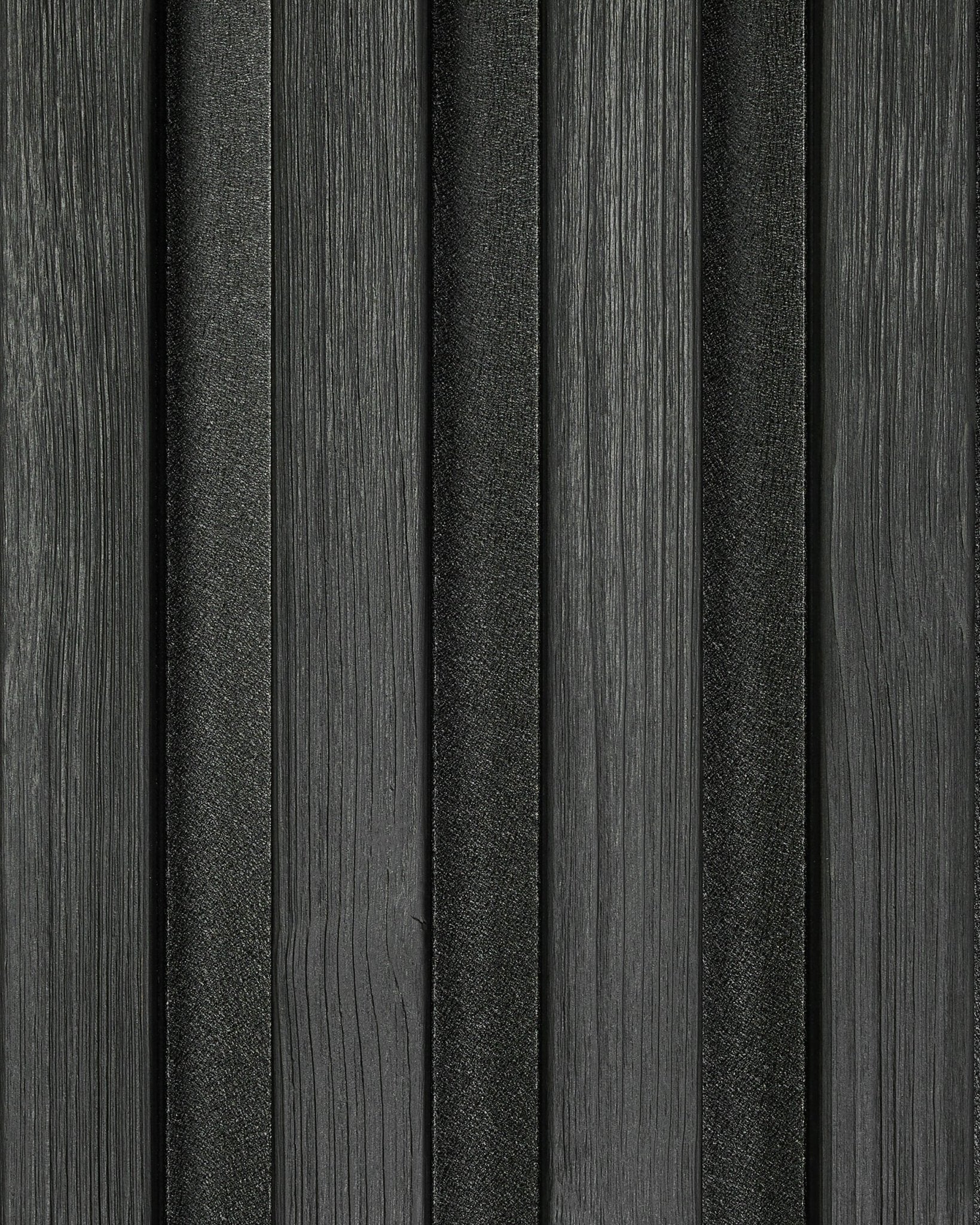 Primer plano de una muestra del panel de fachada Aluwood Black (45,7 x 27 cm) de WoodUpp, con lamas de textura vertical y un moderno patrón de rayas.