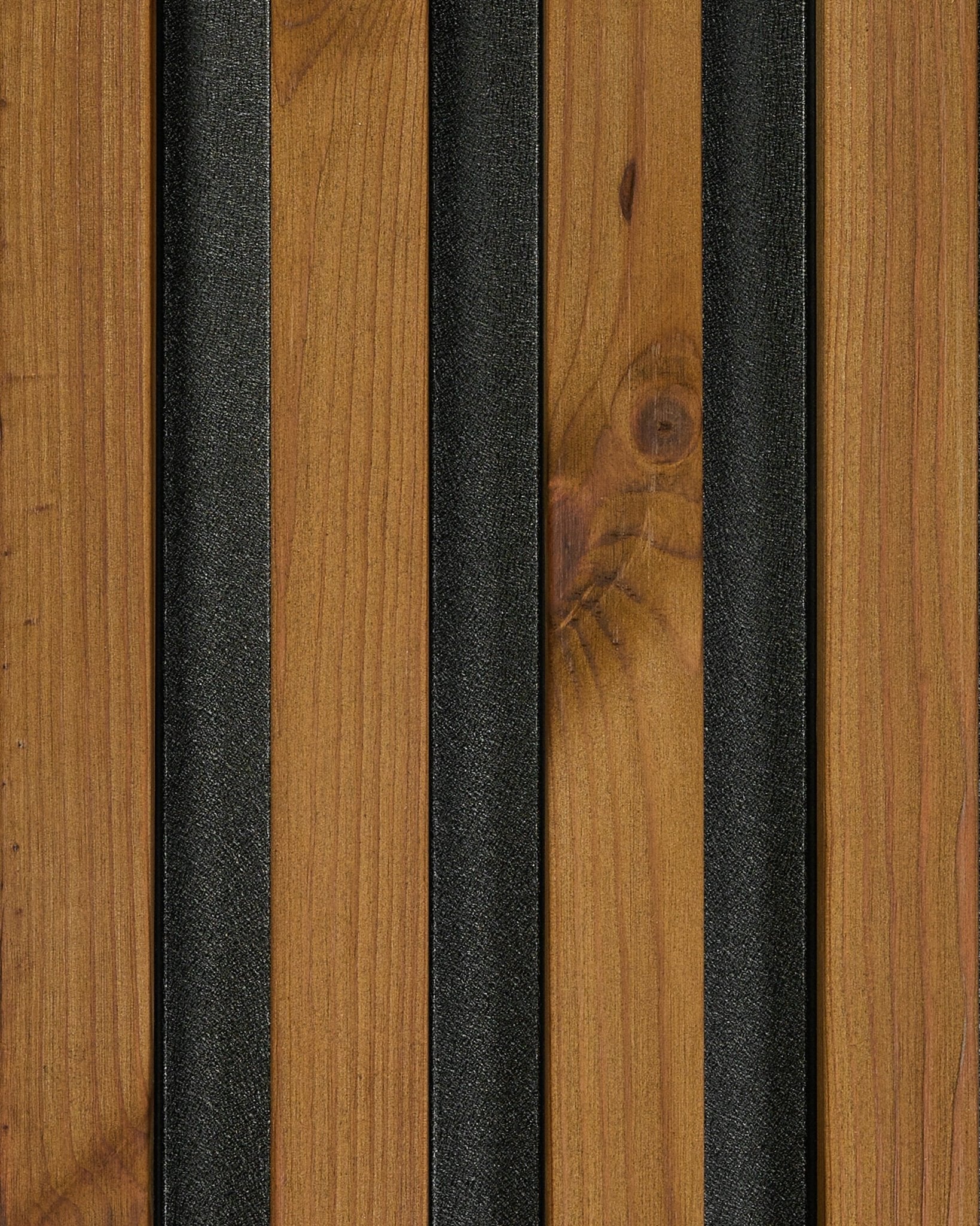 Primer plano de una muestra del panel de fachada WoodUpp Aluwood en acabado brown aceitado (45,7 x 27 cm), que resalta la veta natural wood y las tiras con textura black.