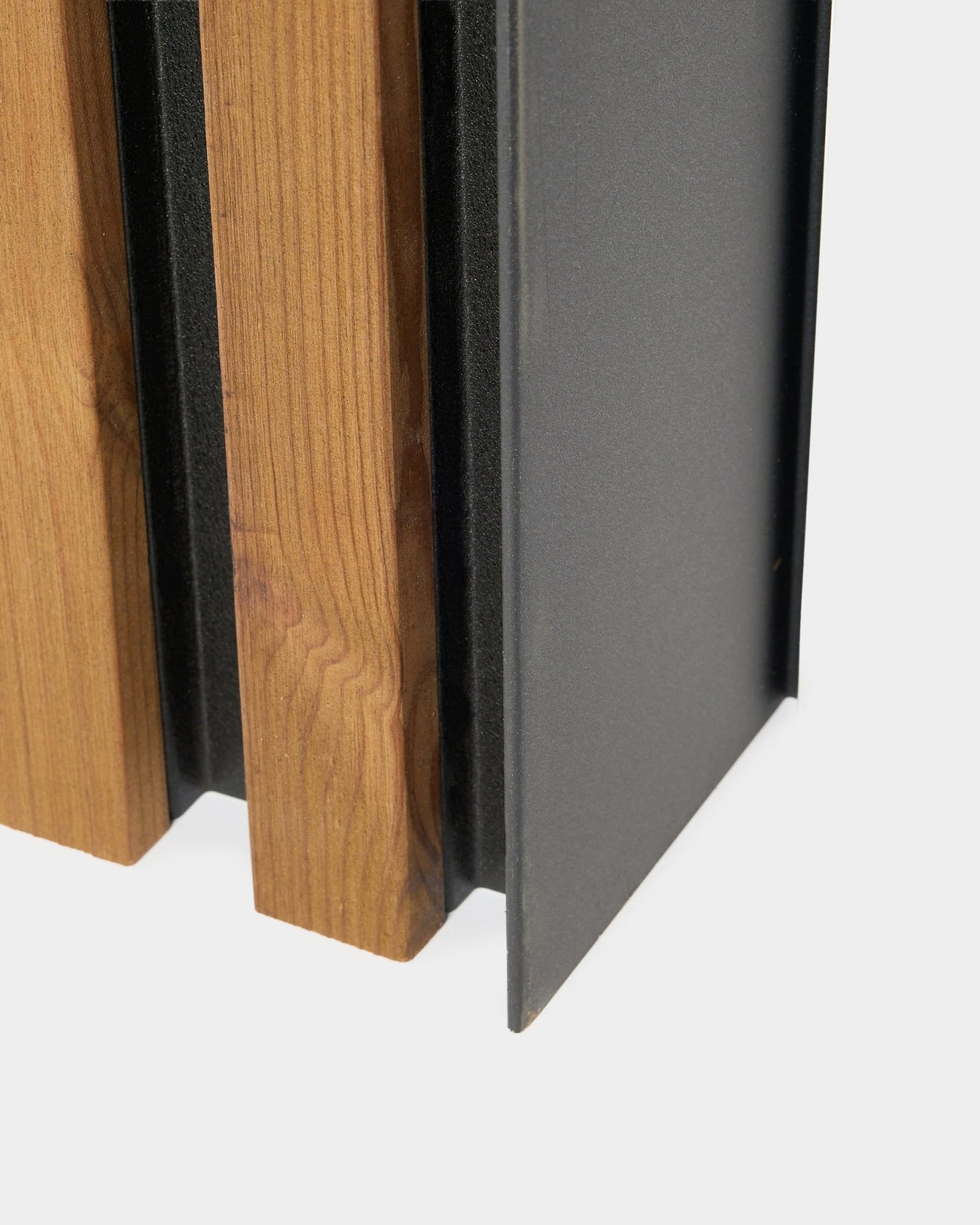 Primer plano del panel de fachada WoodUpp Aluwood, 240 cm, con lamas de madera verticales y un perfil de aluminio con recubrimiento en polvo oscuro para instalación exterior.