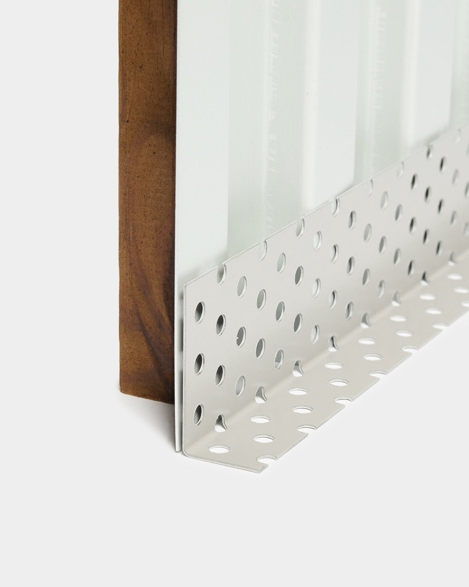 Primer plano de un accesorio para la instalación de paneles de fachada Aluwood: perfil esquinero metálico con perforaciones redondas large, diseñado para cámaras ventiladas, longitud de 240 cm.