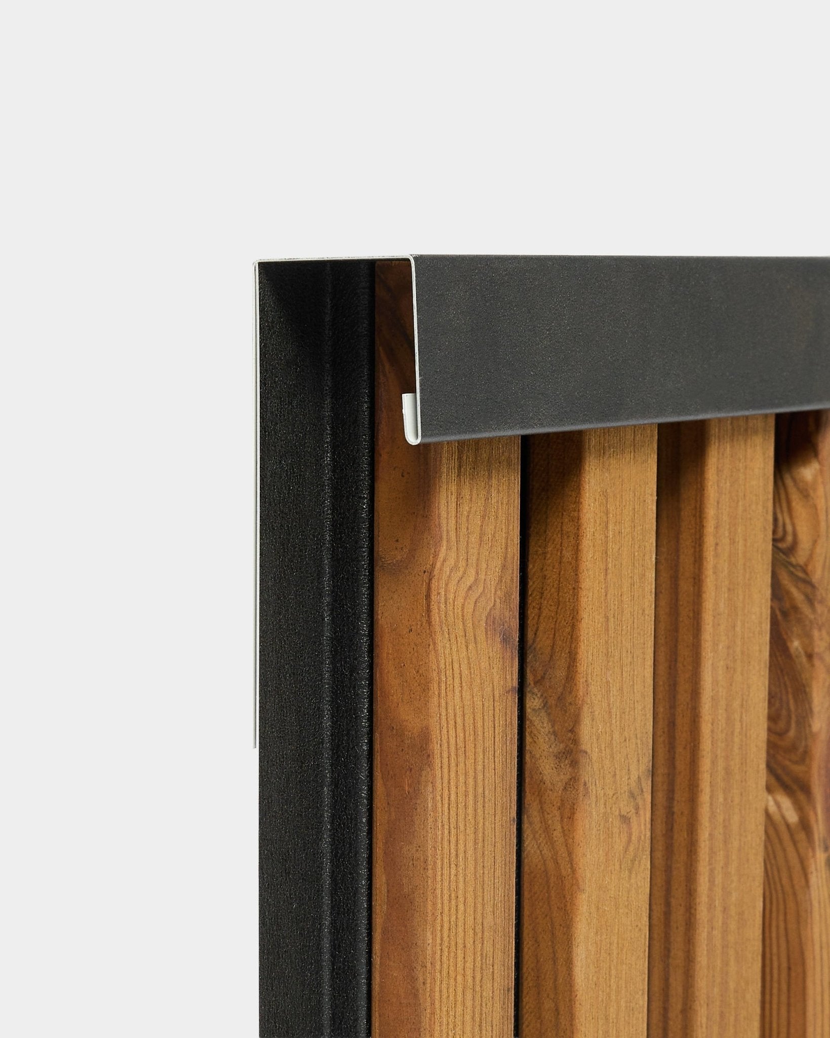 Primer plano del perfil de remate WoodUpp Aluwood de 240 cm con un borde de aluminio black para paneles de fachada exterior, mostrado sobre un fondo blanco.