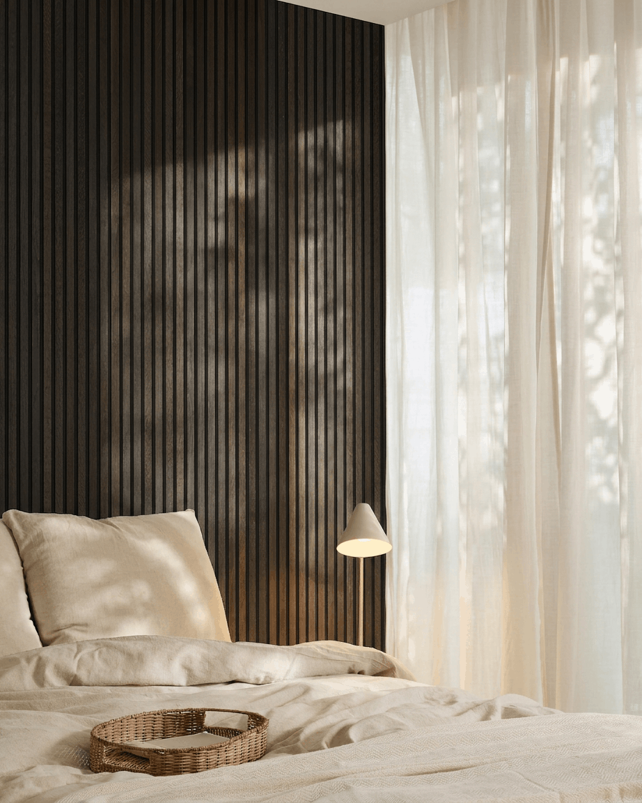 Dormitorio minimalista con una cama beige, una bandeja de mimbre, detalles Scandi y un panel acústico de madera Akupanel de WoodUpp en Rustic Smoked Oak, montado sobre una pared oscura.