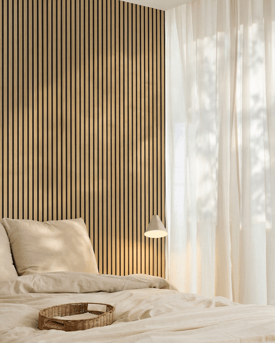 Dormitorio minimalista con ropa de cama beige, una pared de acento WoodUpp Akupanel Southern Oak Panel acústico, una bandeja tejida sobre la cama y cortinas translúcidas que dejan pasar la luz natural.