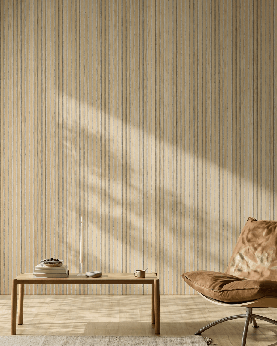 Espacio minimalista con una silla de cuero color canela, una mesa de madera y una vela. El panel acústico de listones WoodUpp Akupanel Classic Oak aporta estilo nórdico y confort acústico.