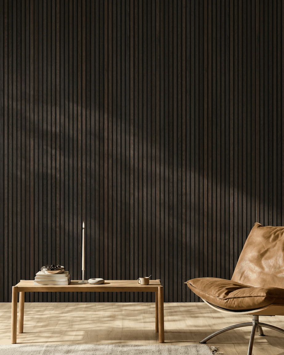Espacio minimalista con una silla de cuero brown, mesa de centro y decoración frente a una pared de paneles acústicos de madera WoodUpp Akupanel Rustic Smoked Oak.