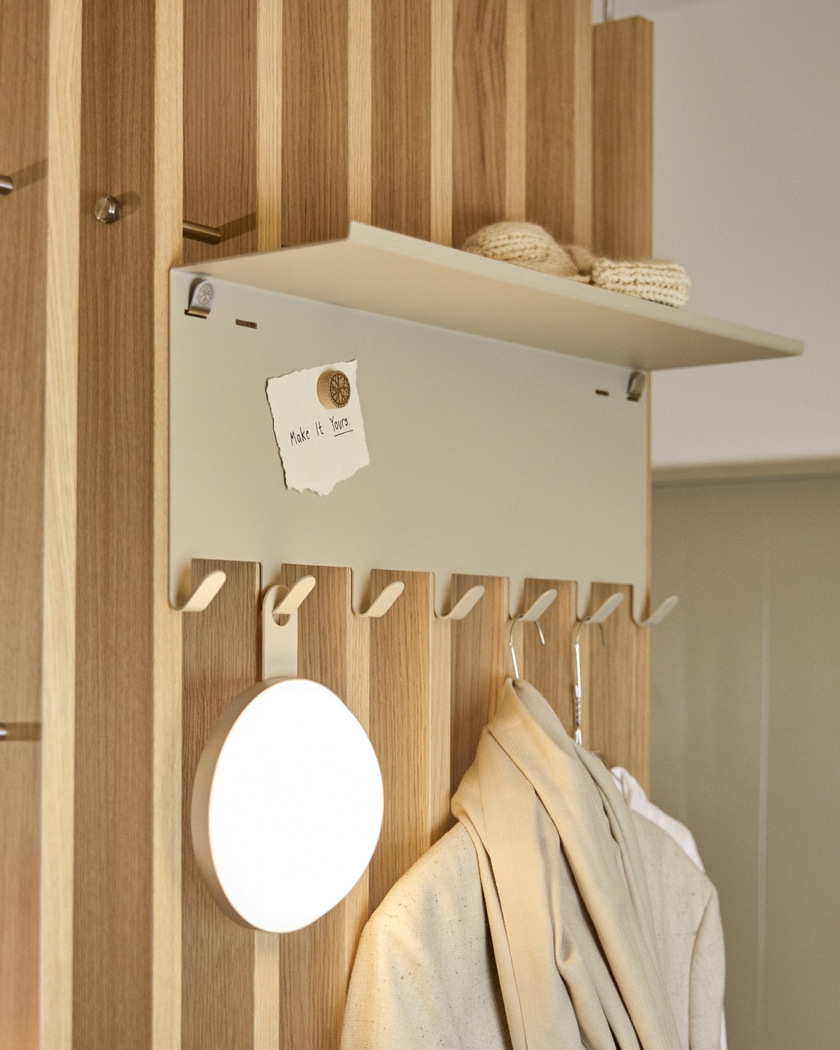 WoodUpp Nell | perchero BM1 en beige (63,5 x 24 cm), con ganchos steel y una balda con prendas de punto y una nota que dice embrace BM1.