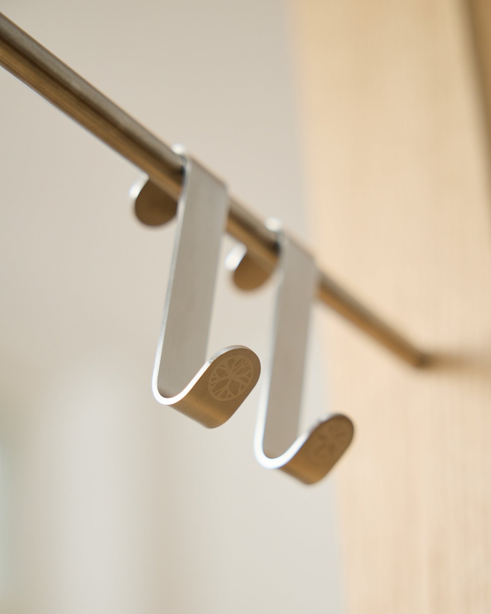 Gancho en S Alva BM1  BM2 de WoodUpp, dos ganchos de acero inoxidable steel con extremos planos grabados, diseñados para colgar accesorios en barras Akupanel horizontal.