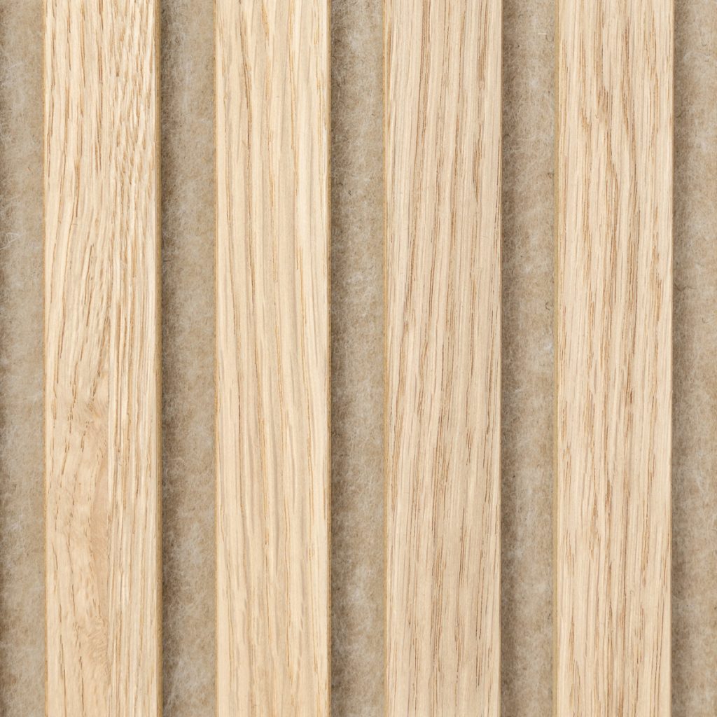 Panel acústico WoodUpp formado por lamas verticales de madera clara tipo roble, textura veteada y cantos rectos, montadas sobre una base beige de fieltro acústico visible entre listones. Detalle del acabado natural y la separación regular y paralela entre lamas.