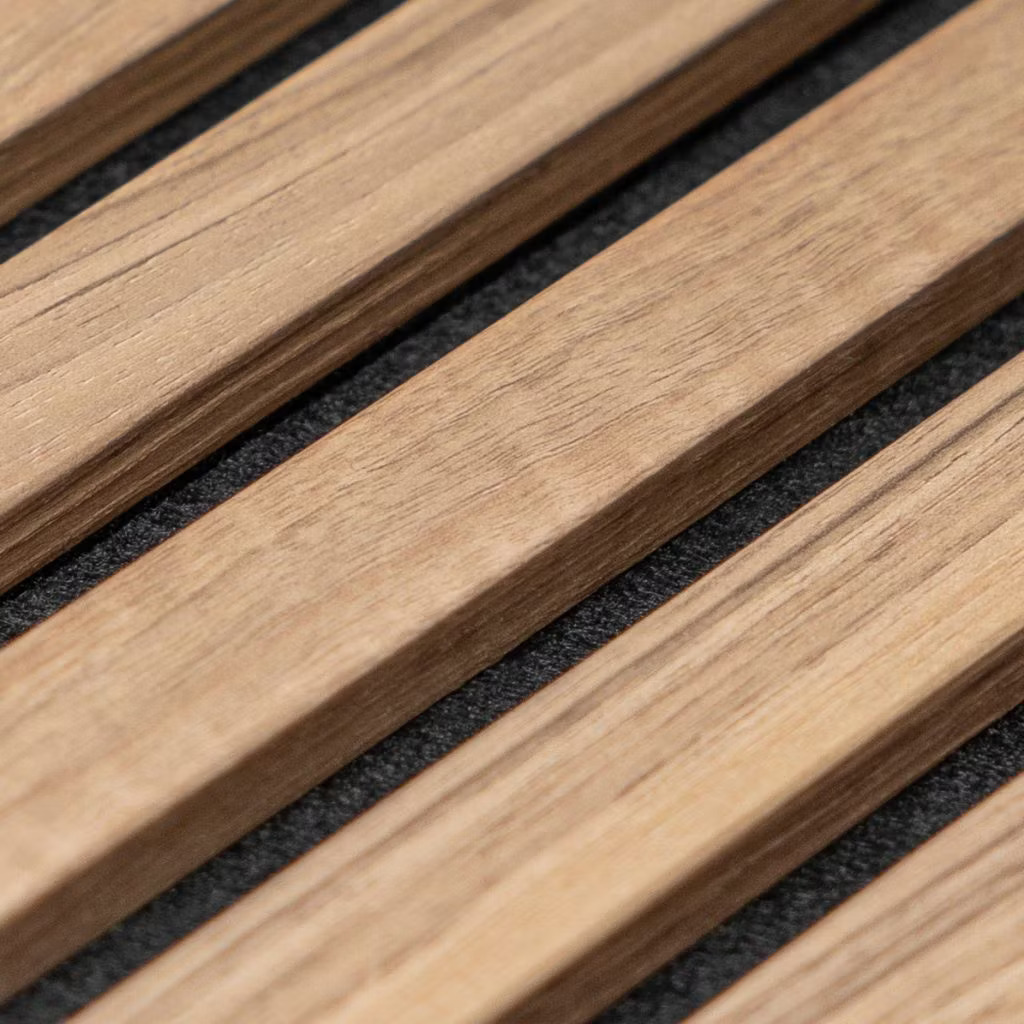 Primer plano de lamas acústicas de madera WoodUpp: listones rectangulares de roble claro con vetas naturales y cantos suaves, colocados en paralelo sobre un respaldo textil negro. Producto WoodUpp que combina acabado mate y distancia uniforme entre lamas para control acústico y estética contemporánea.